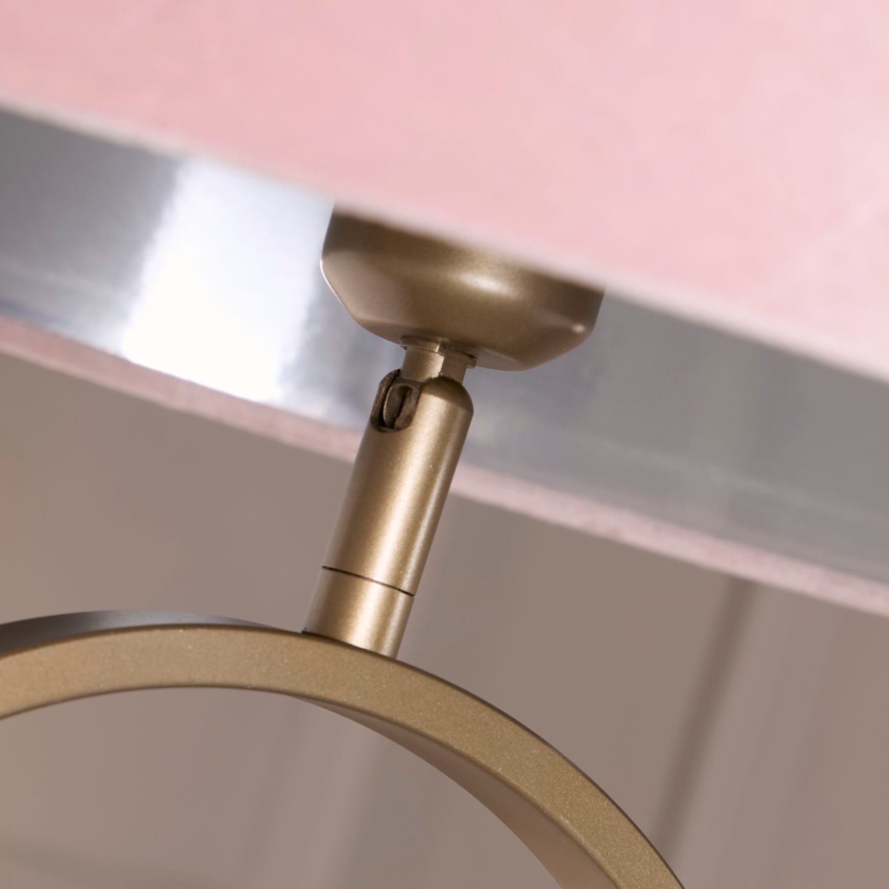 Close up of the adjustable bulb holder joint beneath the pink velvet shade on the Modish floor lamp