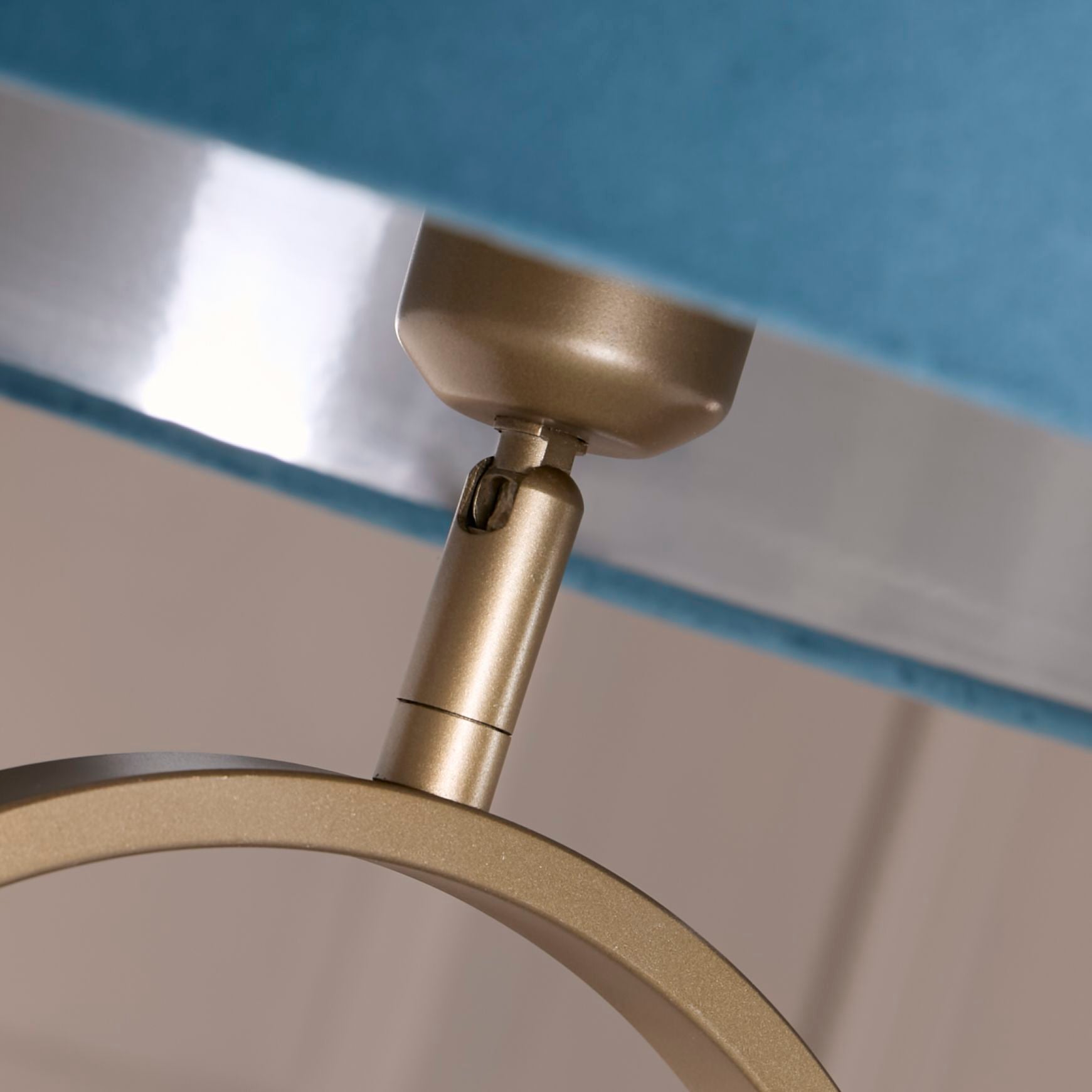 Close up of the adjustable bulb holder joint beneath the teal velvet shade on the Modish floor lamp