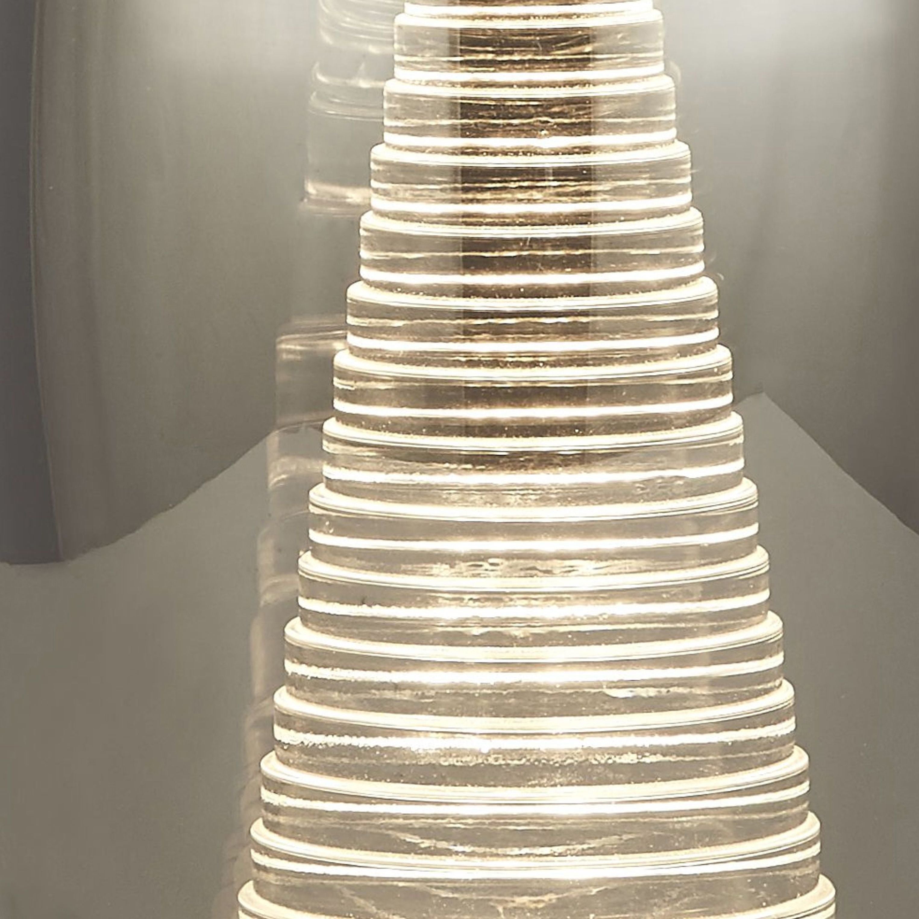 Close up of the illuminated ribbed acrylic cone inside the Cyclone table lamp's smoked glass shade