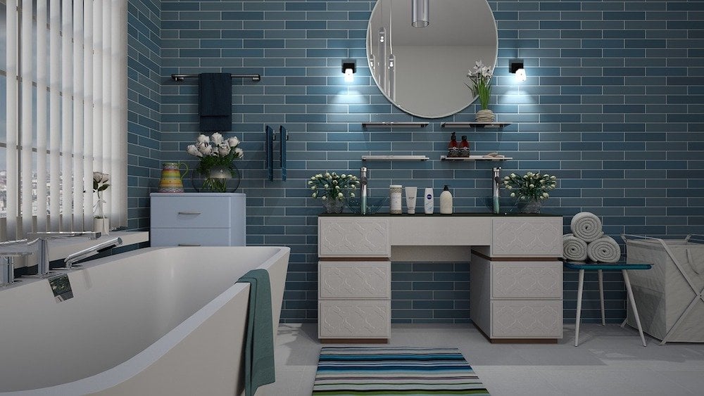 Modern bathroom with blue tiled wall and white fixtures