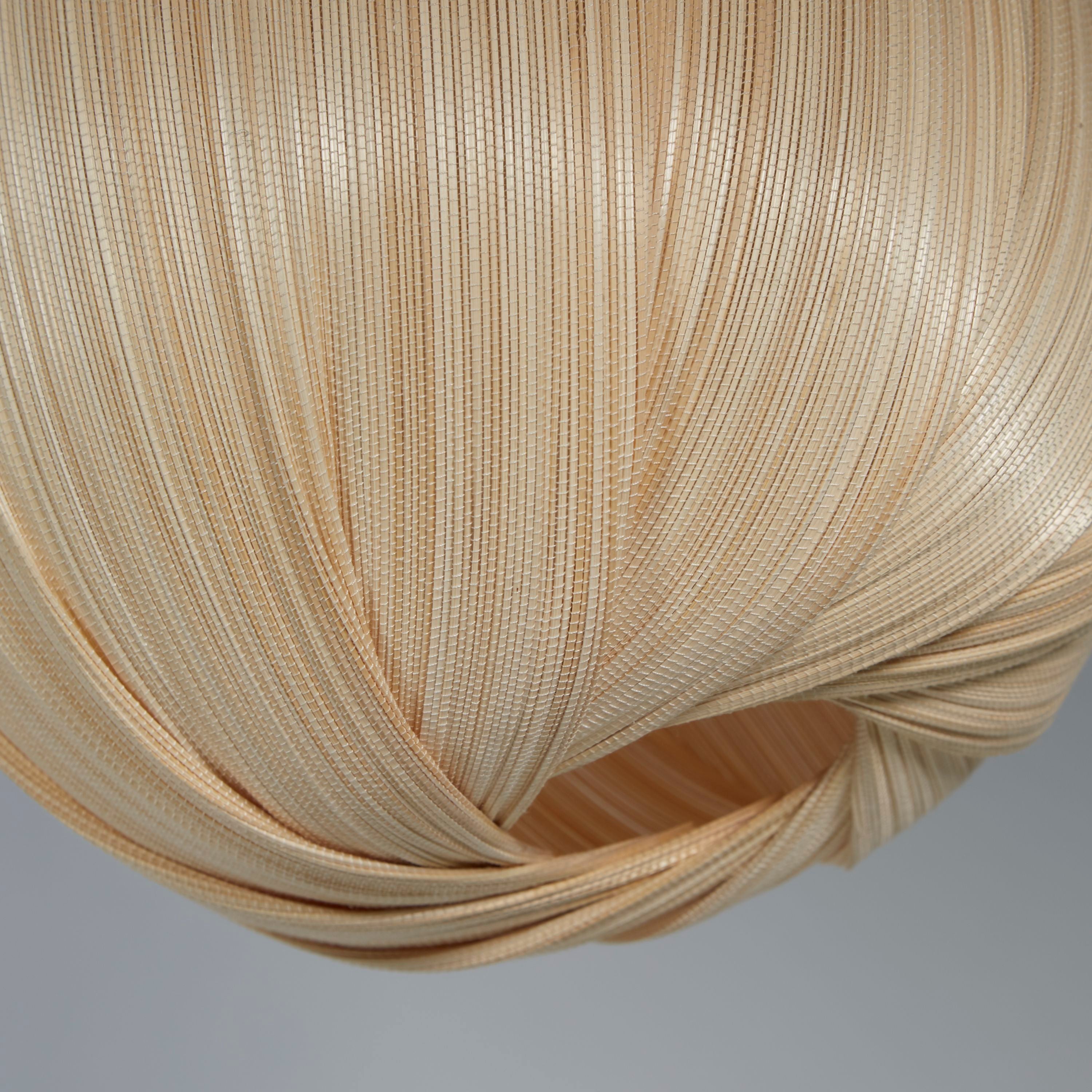 Close up of the woven bamboo strand texture and the twisted base opening of the natural round bamboo shade