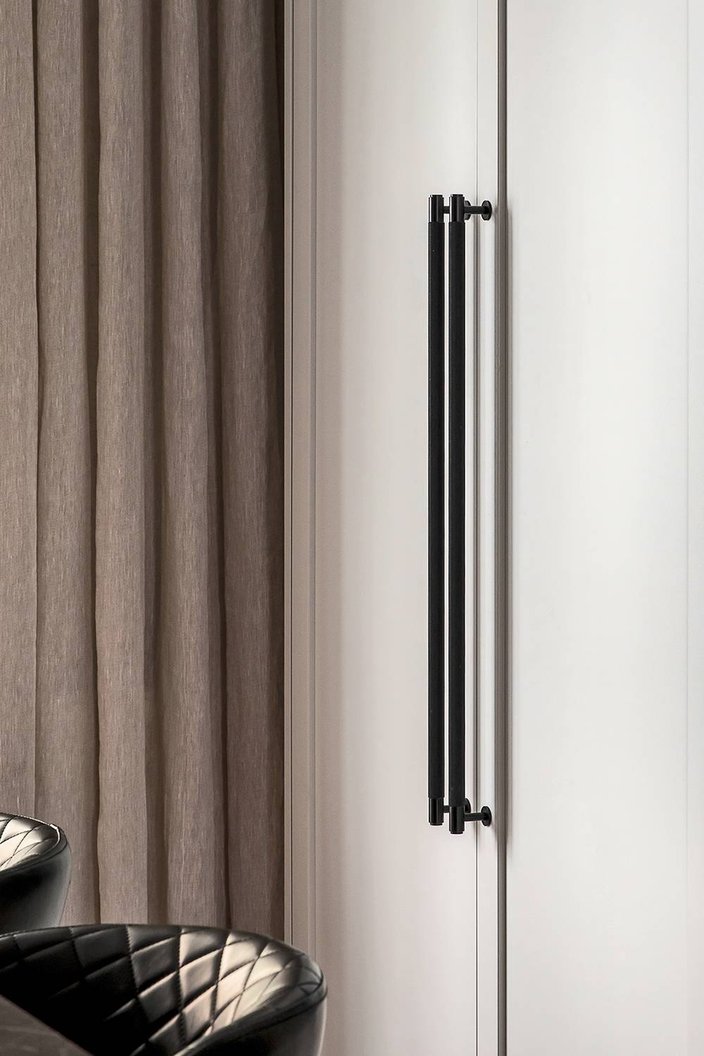 Two Black Cross Knurl closet bars mounted side by side on a wardrobe door