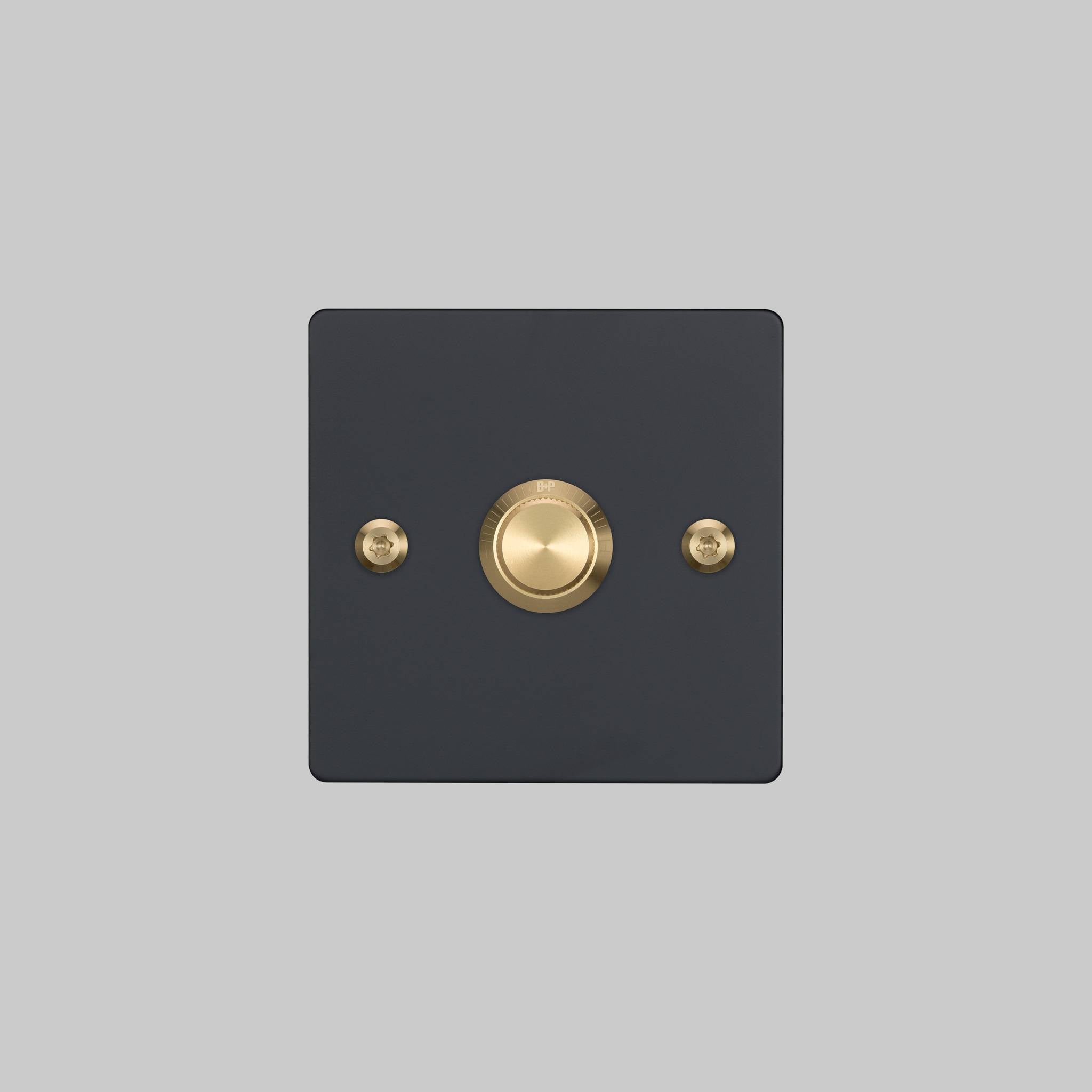 Buster + Punch 1G dimmer switch, black plate with brass linear knurl knob, elevated angle