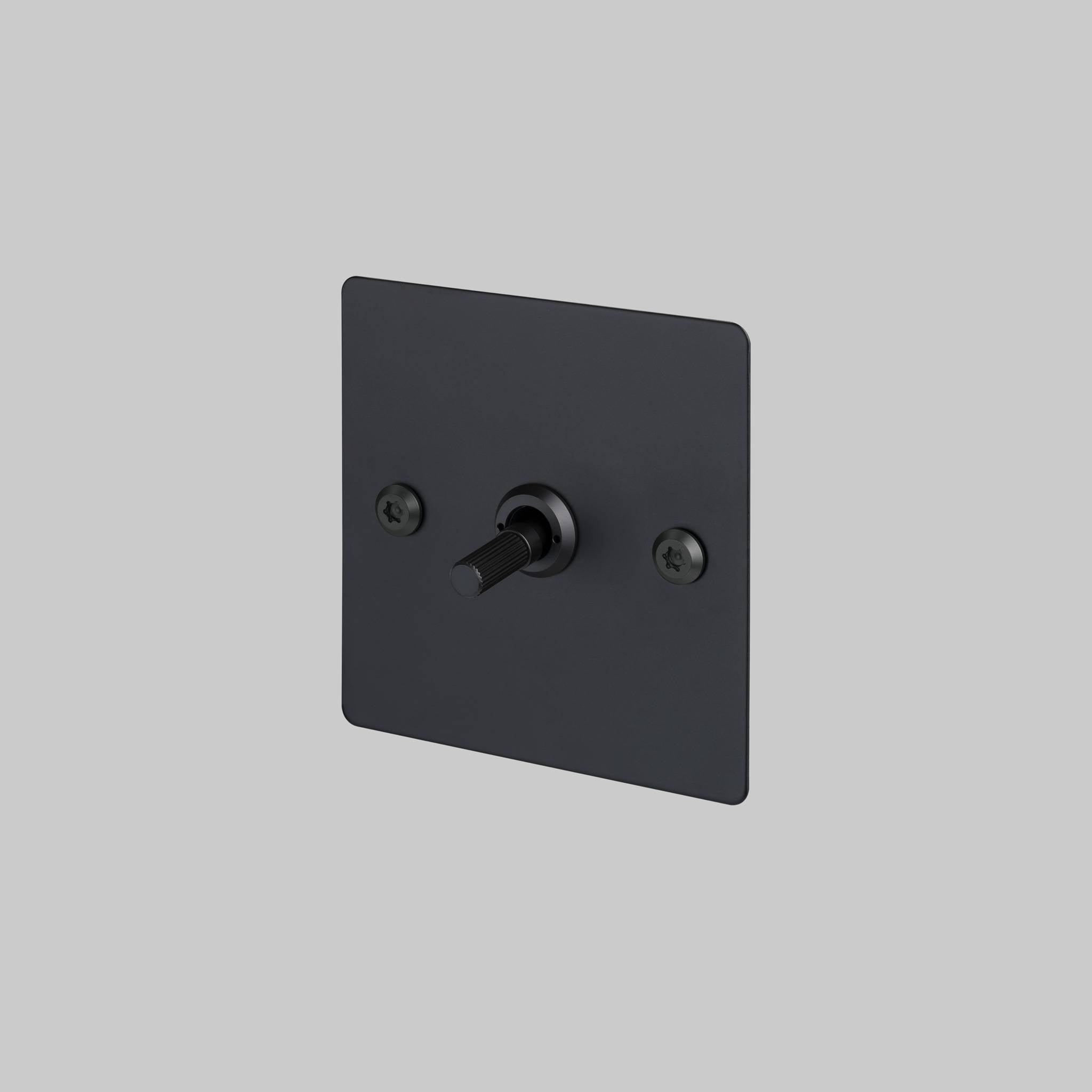 Buster + Punch 1G intermediate 3 way toggle switch, Black plate with Black linear knurl toggle arm, elevated angle view