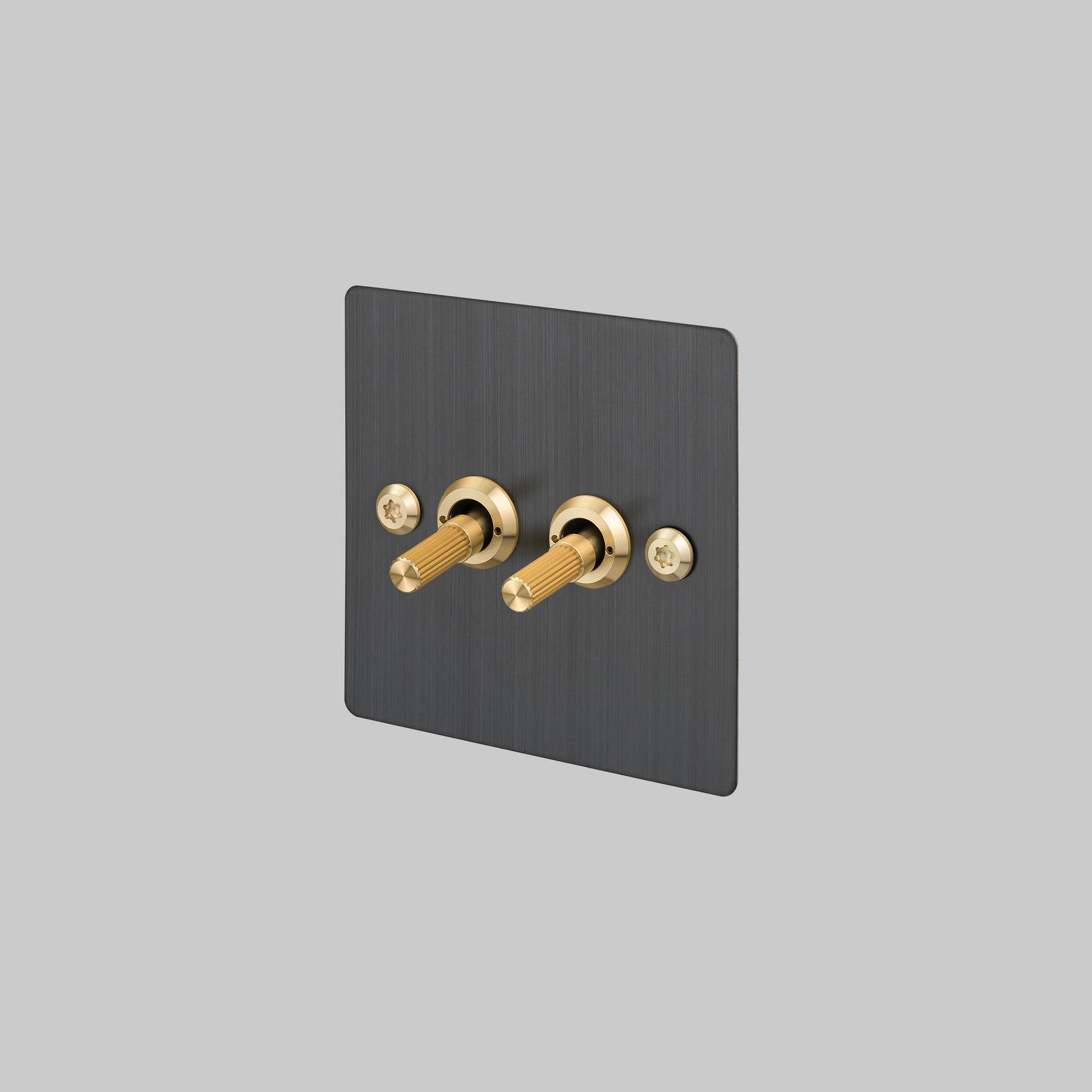 Buster + Punch 2G 2-way toggle switch, smoked bronze plate with brass linear knurl toggle arm, front view