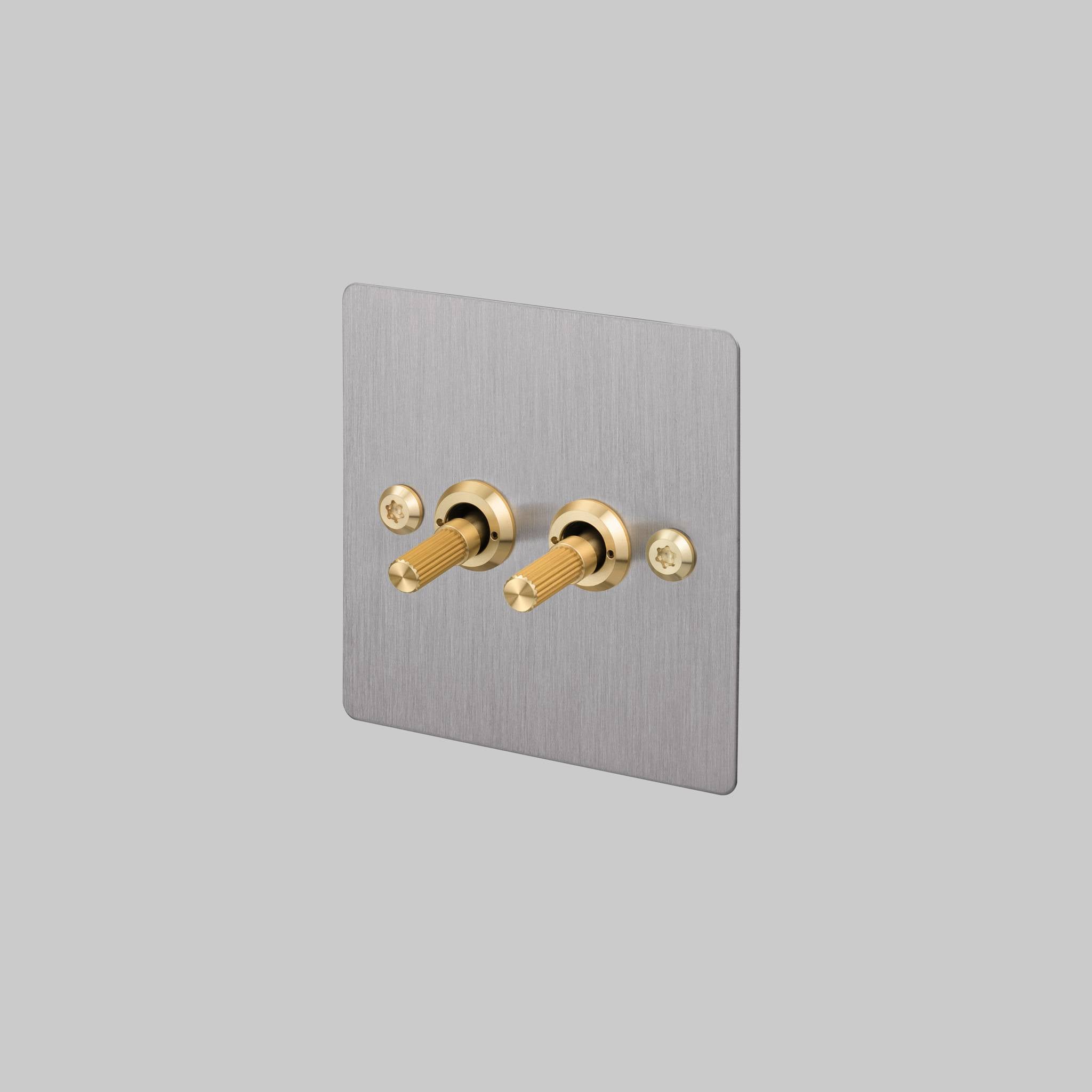Buster + Punch 2G 2-way toggle switch, steel plate with brass linear knurl toggle arm, front view