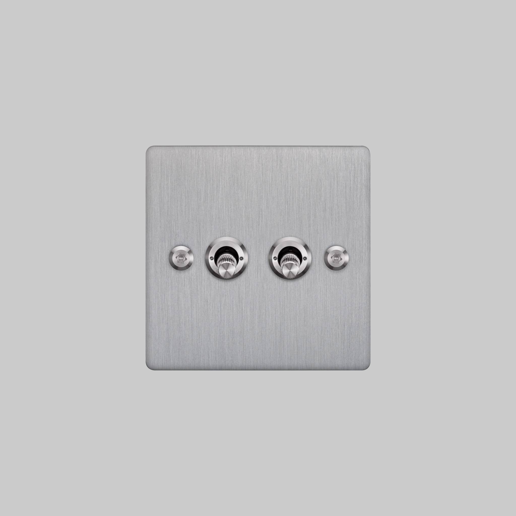 Buster + Punch 2G 2-way toggle switch, steel plate with steel linear knurl toggle arm, elevated angle view