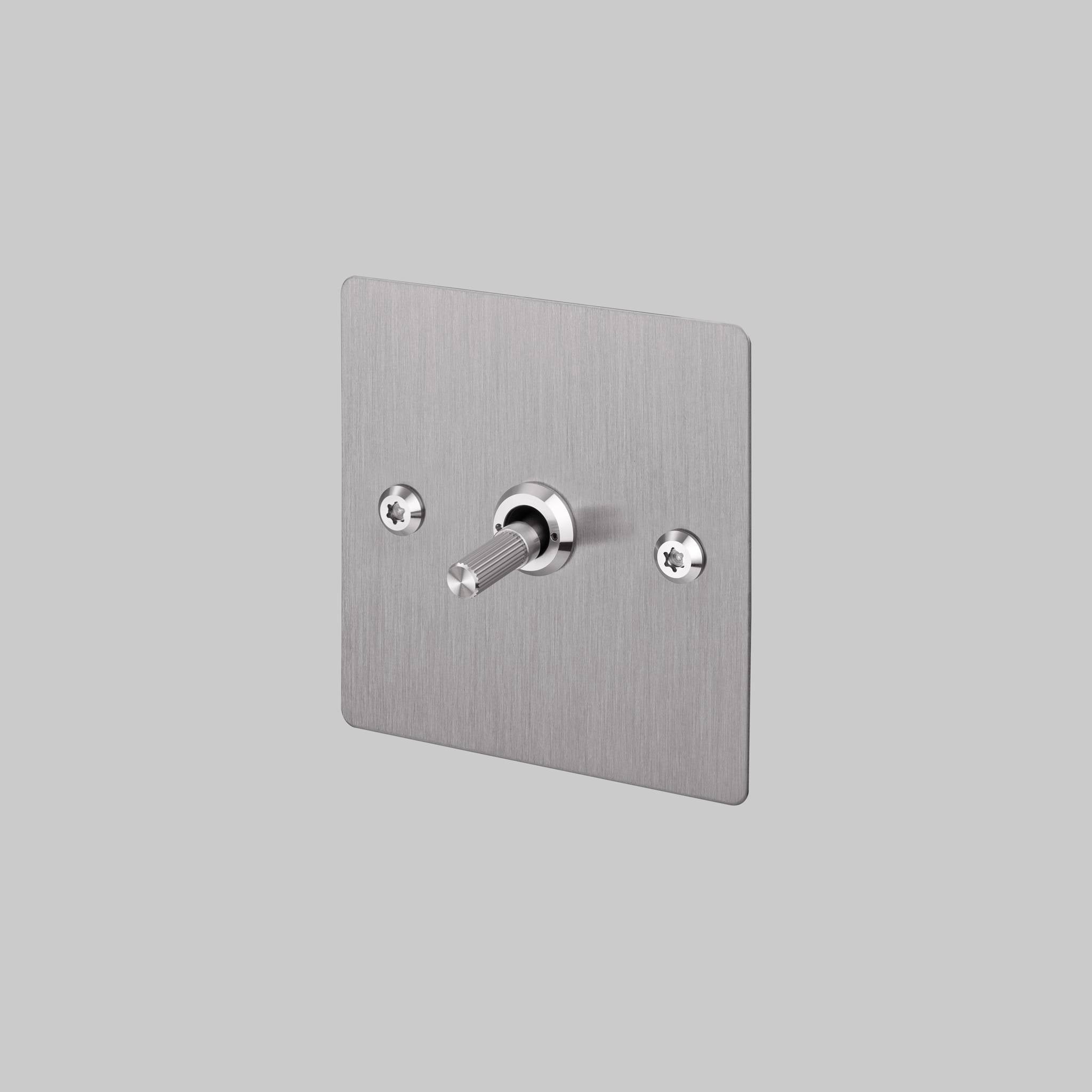 Buster + Punch 1G intermediate toggle switch, steel plate with steel linear knurl toggle arm, front view