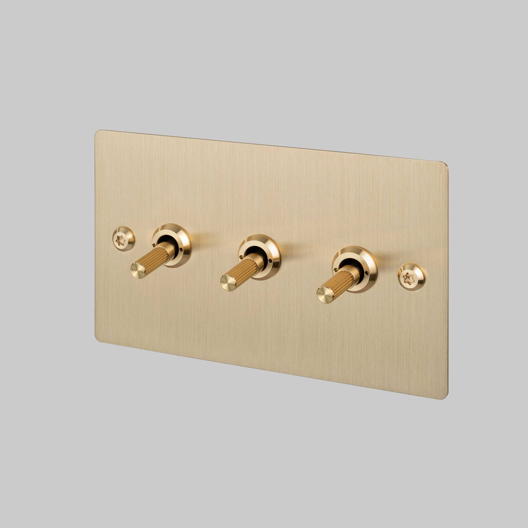 Buster + Punch 3G toggle switch, Brass plate with Brass linear knurl toggle arm, front angled view