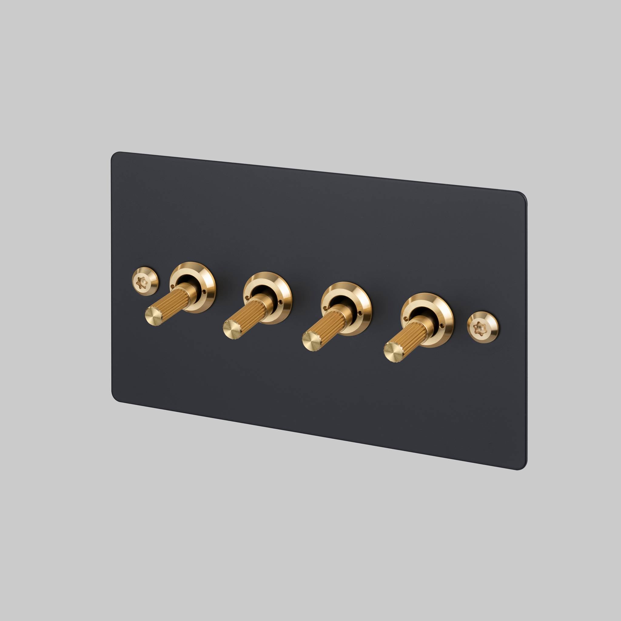 Buster + Punch 4G toggle switch, black plate with brass linear knurl toggle arms, front view