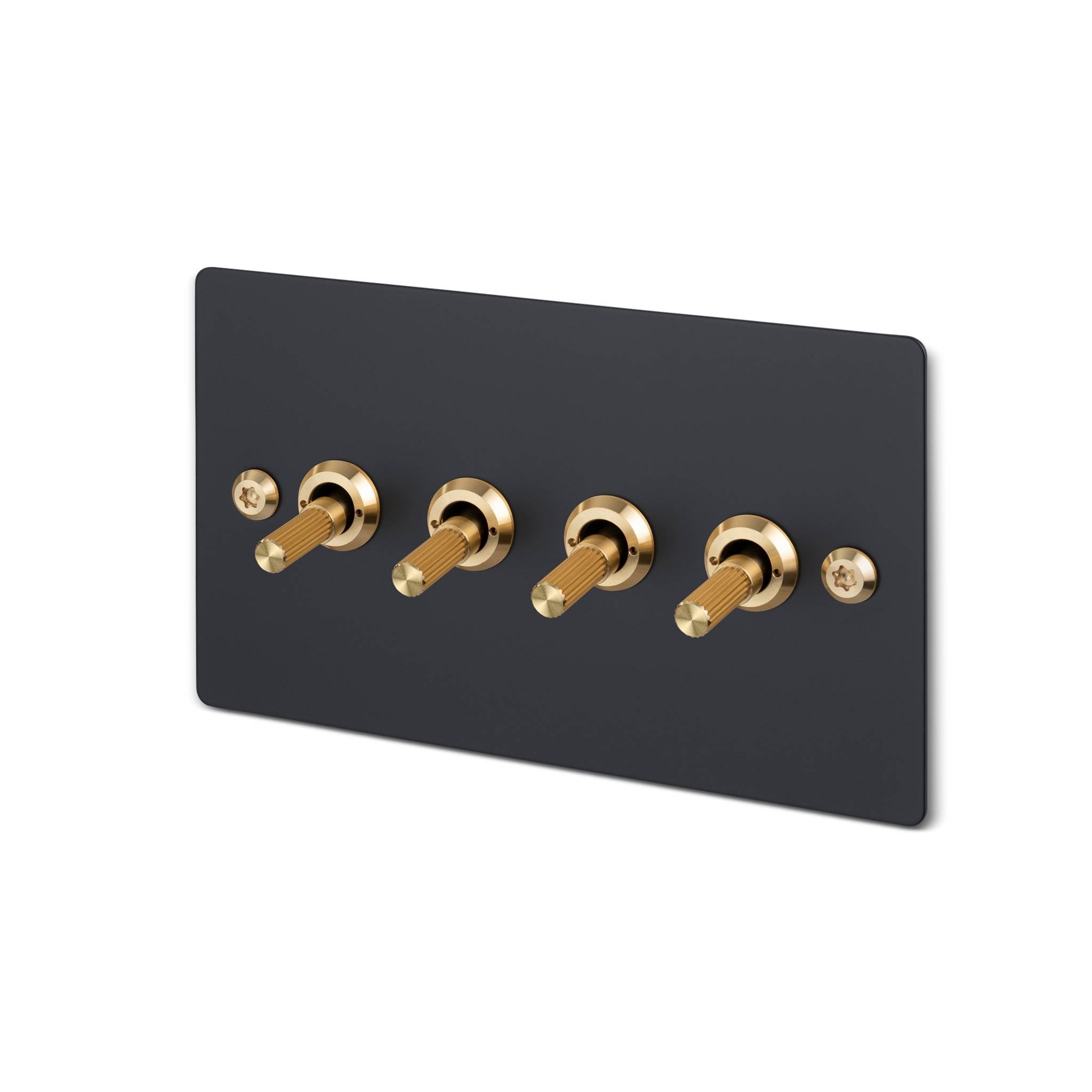 Buster + Punch 4G toggle switch, black plate with brass linear knurl toggle arms, isolated cutout