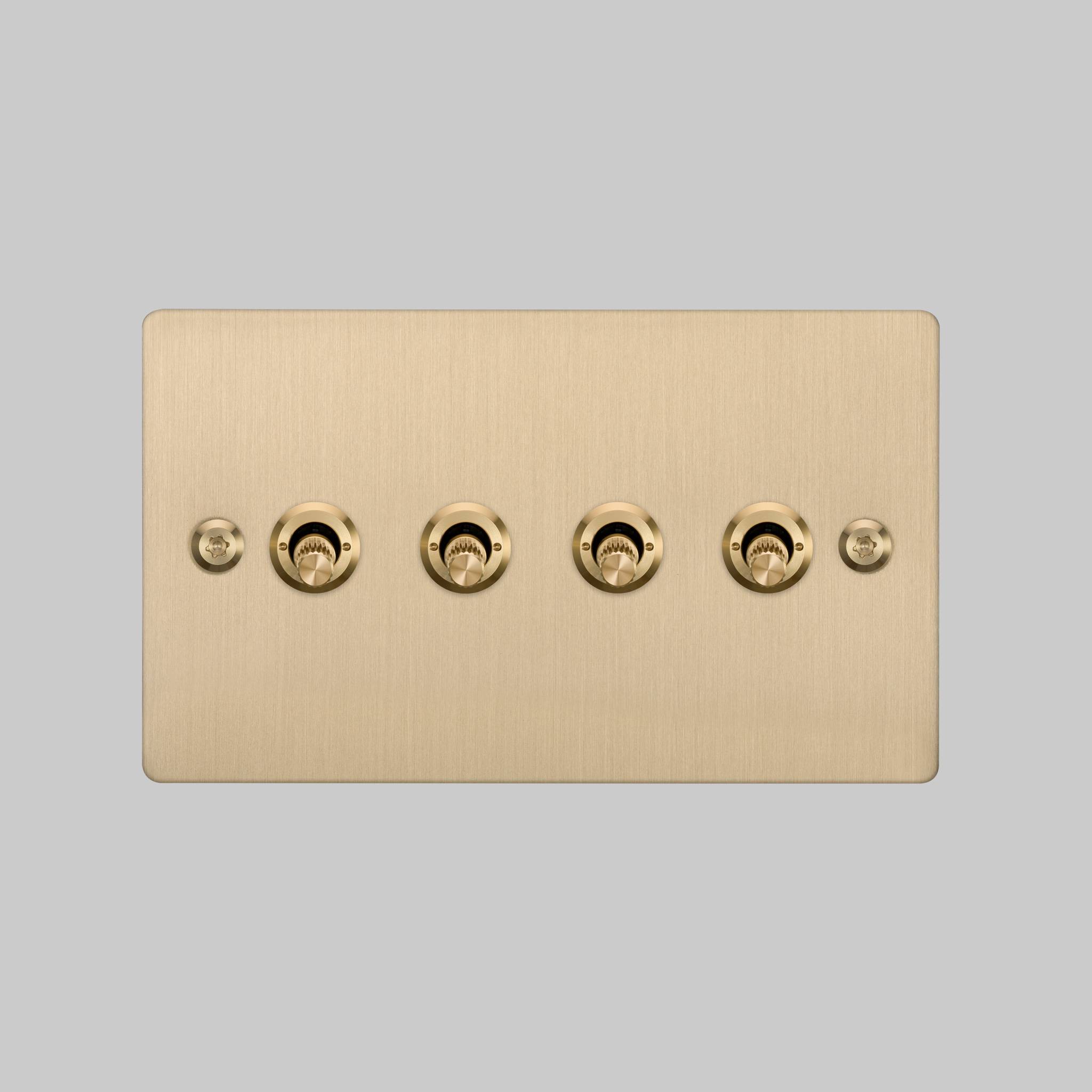 Buster + Punch 4G toggle switch, brass plate with brass linear knurl toggle arms, elevated angle view