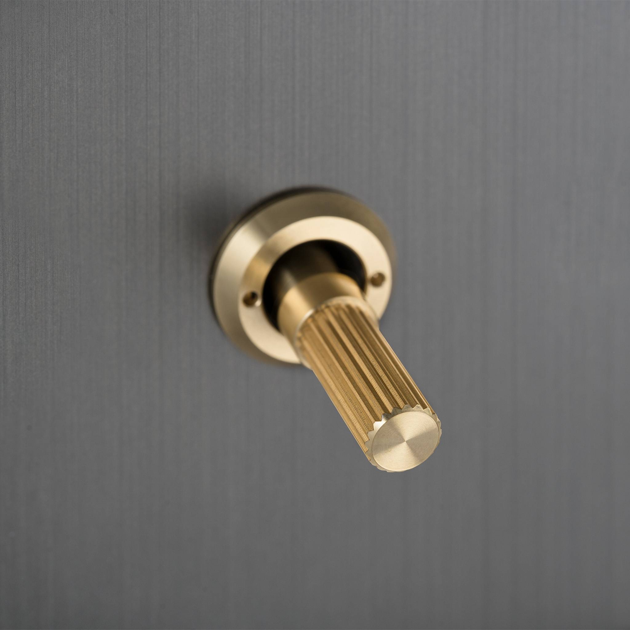 Buster + Punch 3G toggle switch, close up of the Brass linear knurl toggle arm detail on Smoked Bronze plate