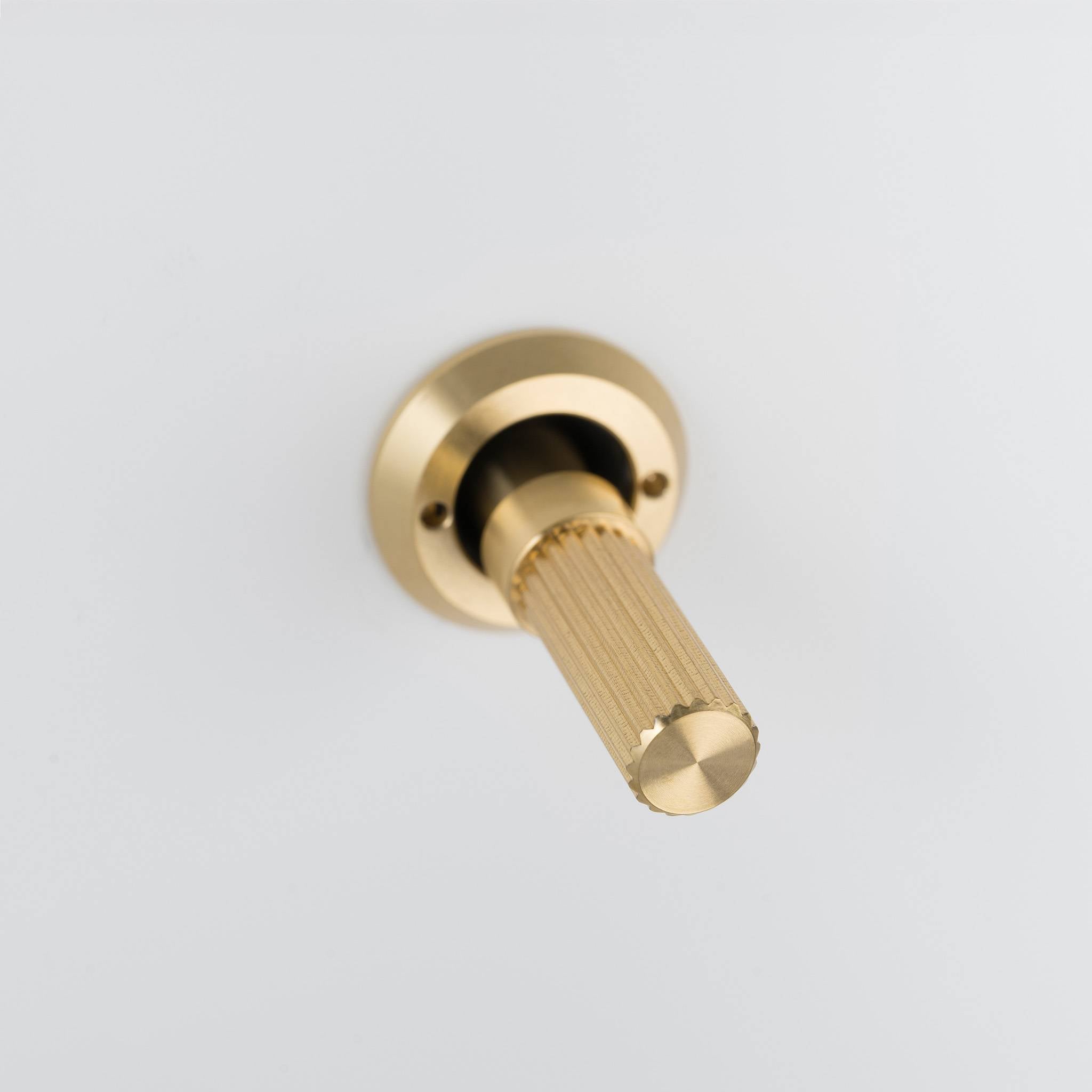 Buster + Punch 3G 2-way toggle switch, White plate with Brass linear knurl toggle arm, close up of the knurl detail