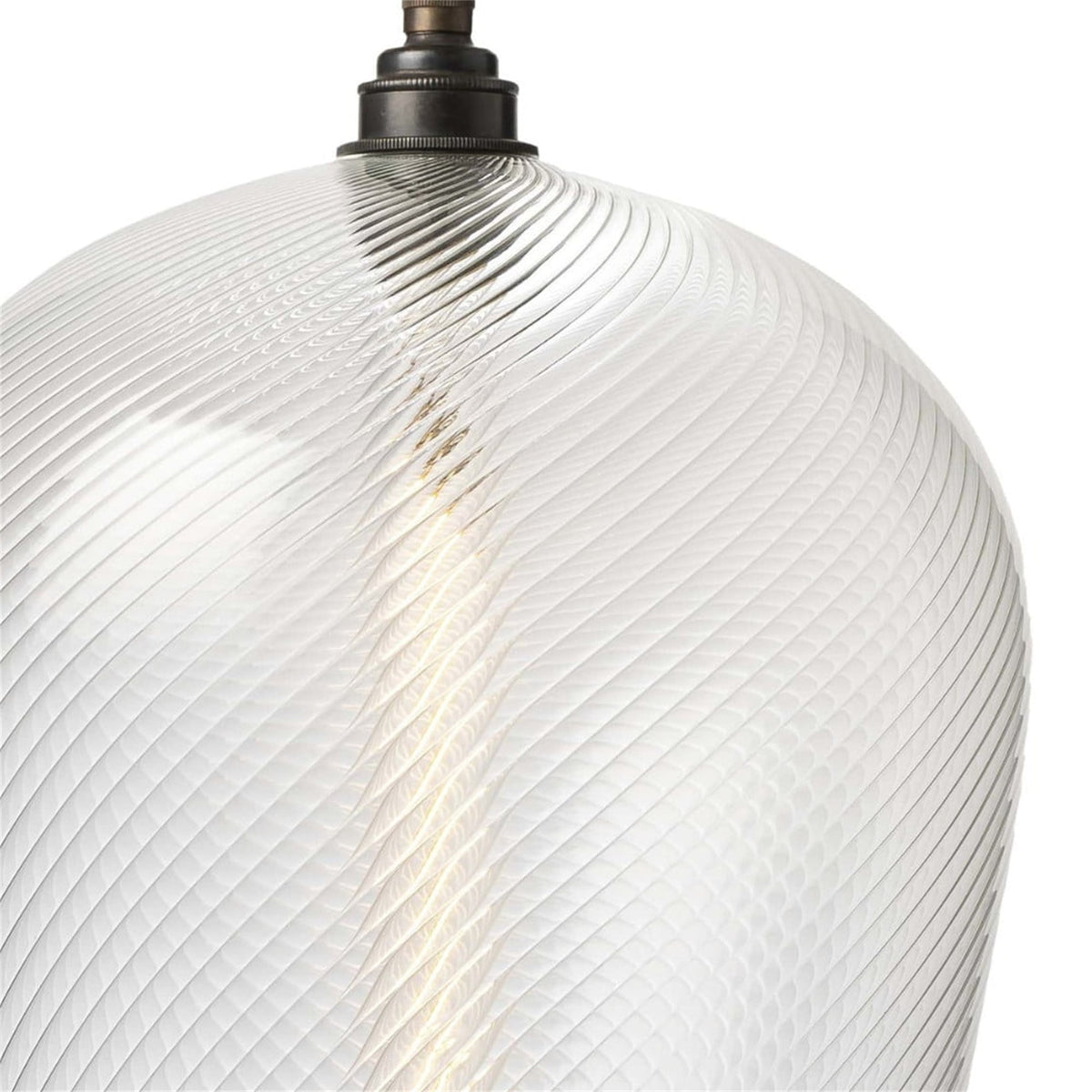 Close up of the clear twisted ribbed glass of a Leverint Waterloo pendant shade with a dark bronze toned lamp holder at the top, studio shot on white