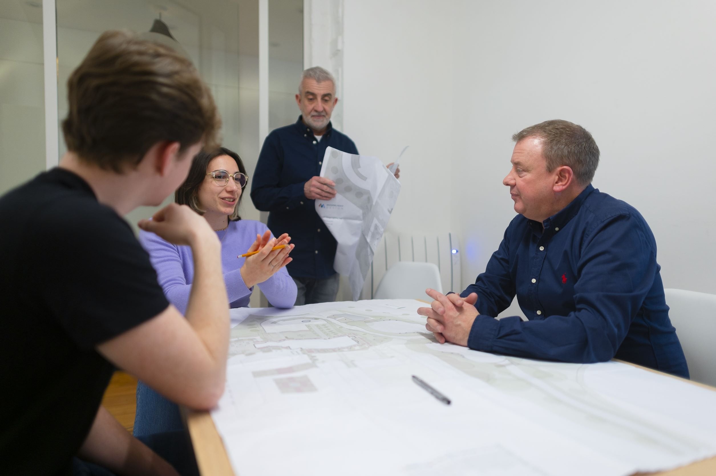 Group of people in a meeting around a table.