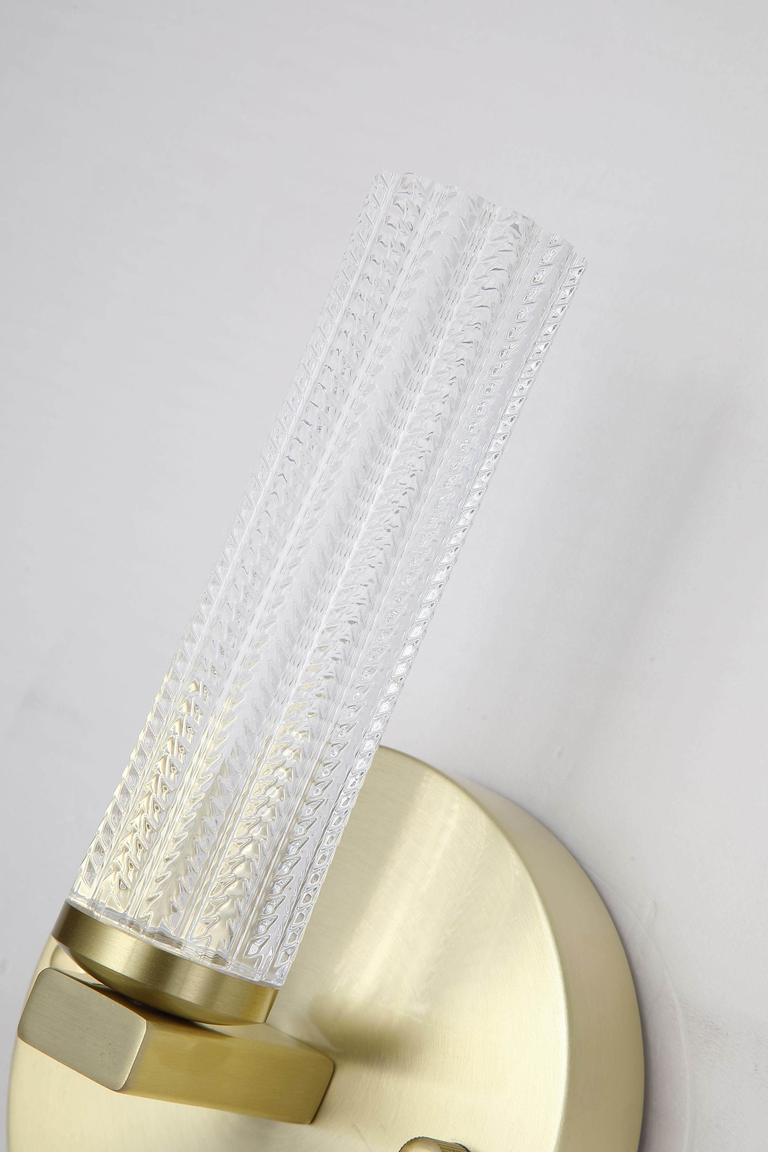 Close up of the Aberdeen wall light's fluted acrylic diffuser and satin brass mounting bracket