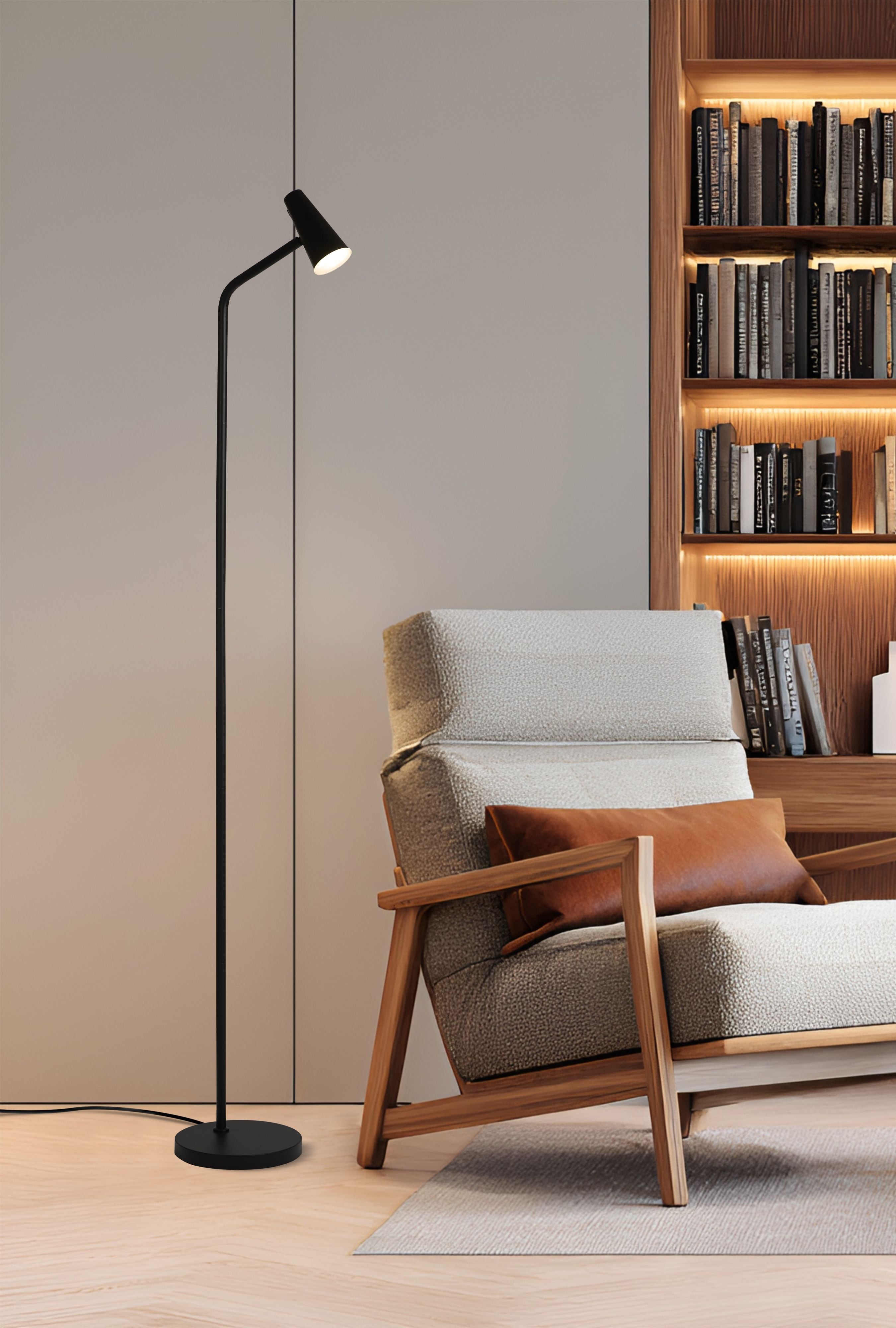 Searchlight Rechargeable Floor Lamp switched on beside an armchair and bookshelf in a living room