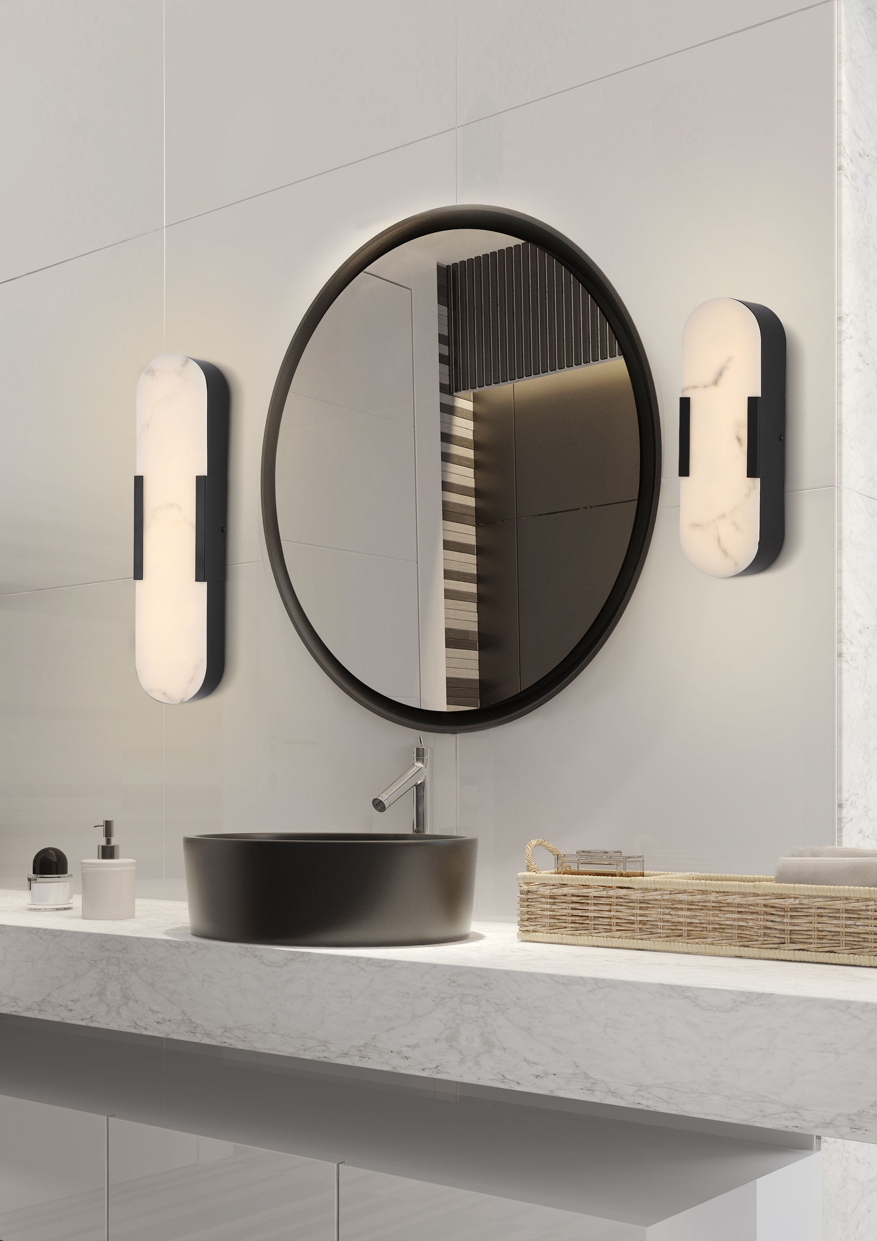 A pair of matt black Opaline wall lights mounted either side of a round mirror above a black vessel sink in a styled marble bathroom