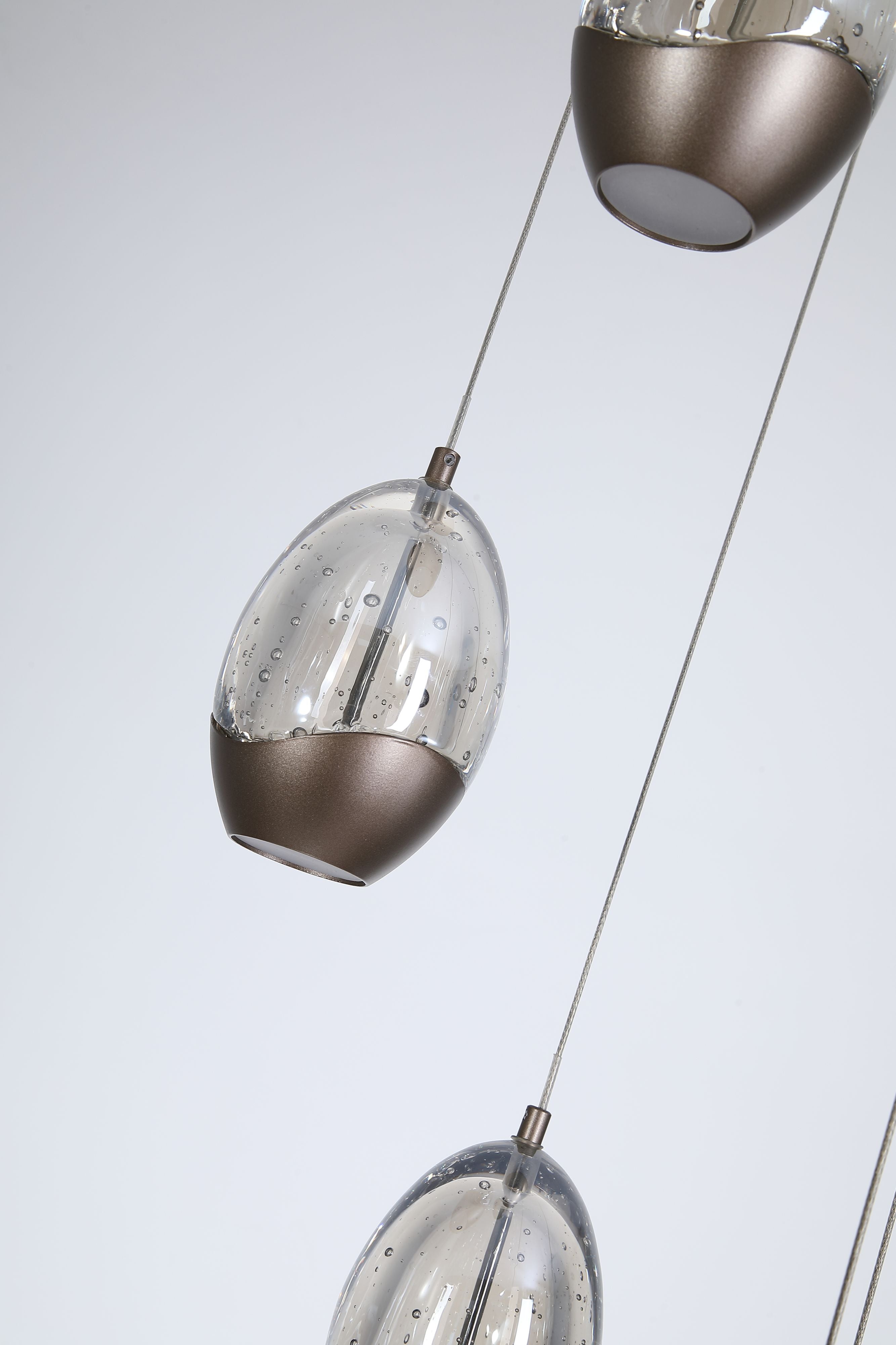 Close up of Seeds multi drop pendant teardrop shades, showing the bubble textured clear glass and dark bronze metal caps