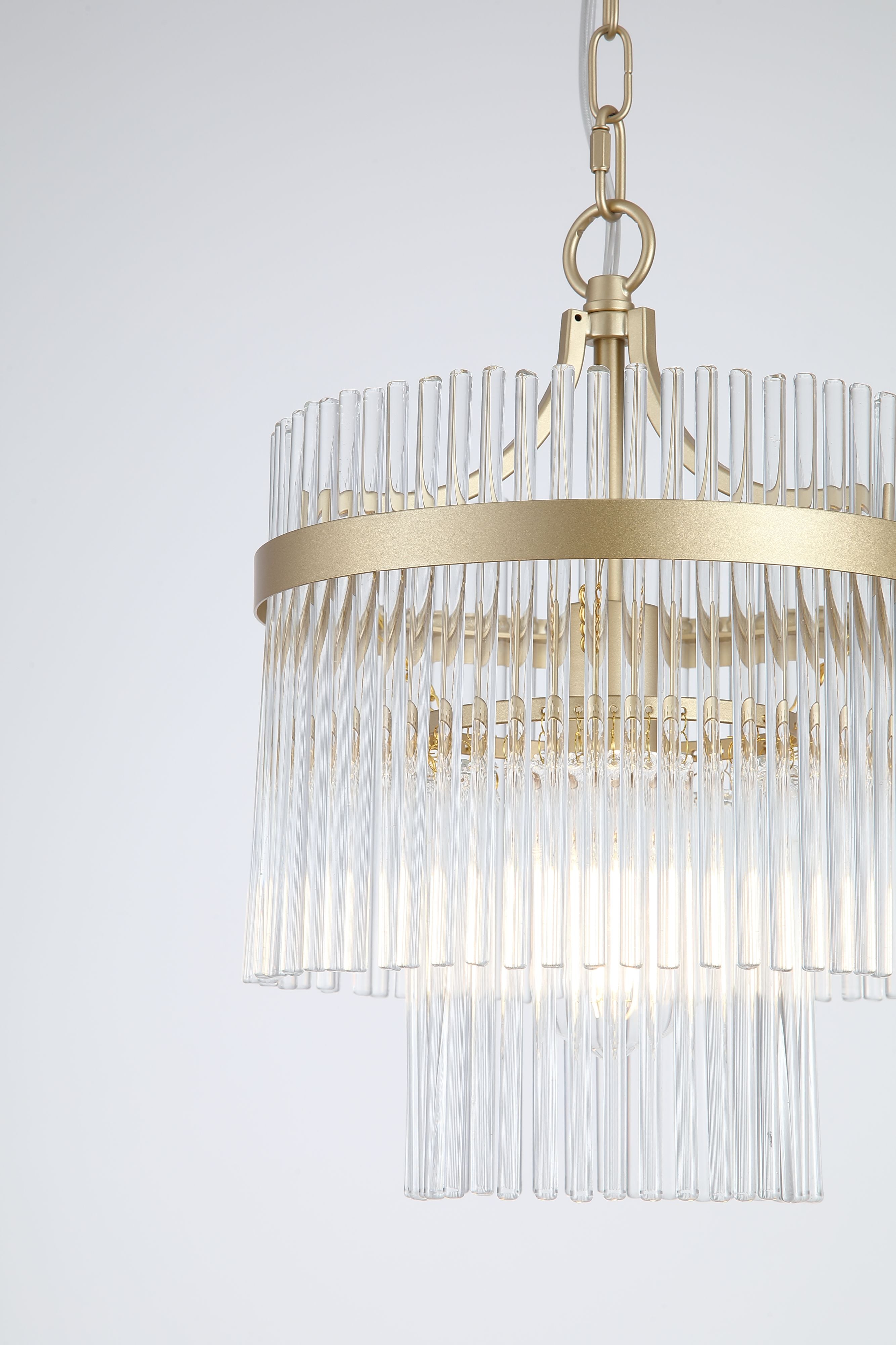 Close up of the Lara 1 light pendant's gold band and clear glass rods with the bulb glowing inside
