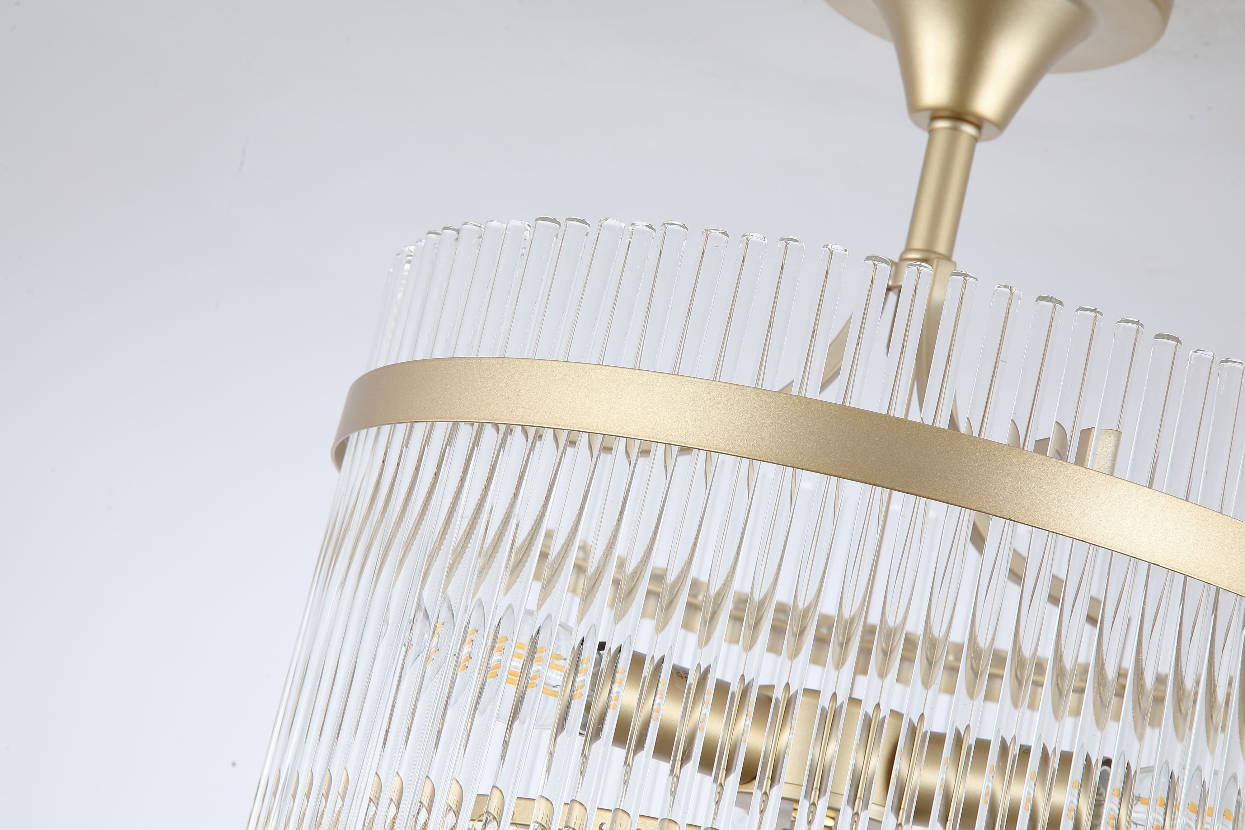 Close up of the Lara semi flush light's gold band and clear glass rods with the bulbs glowing inside the fringed shade