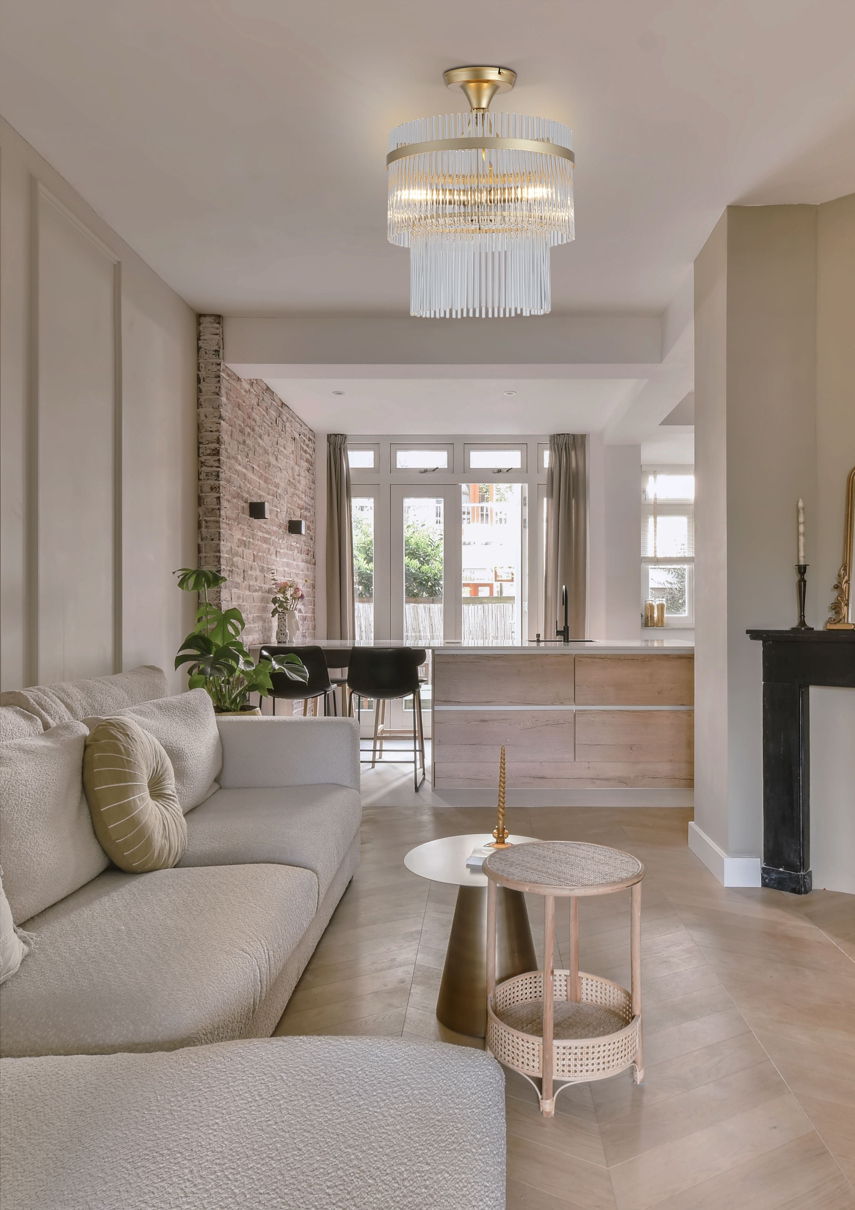 Searchlight Lara 3 light semi flush in gold and clear glass fitted to the ceiling of an open plan living and kitchen space with an exposed brick wall