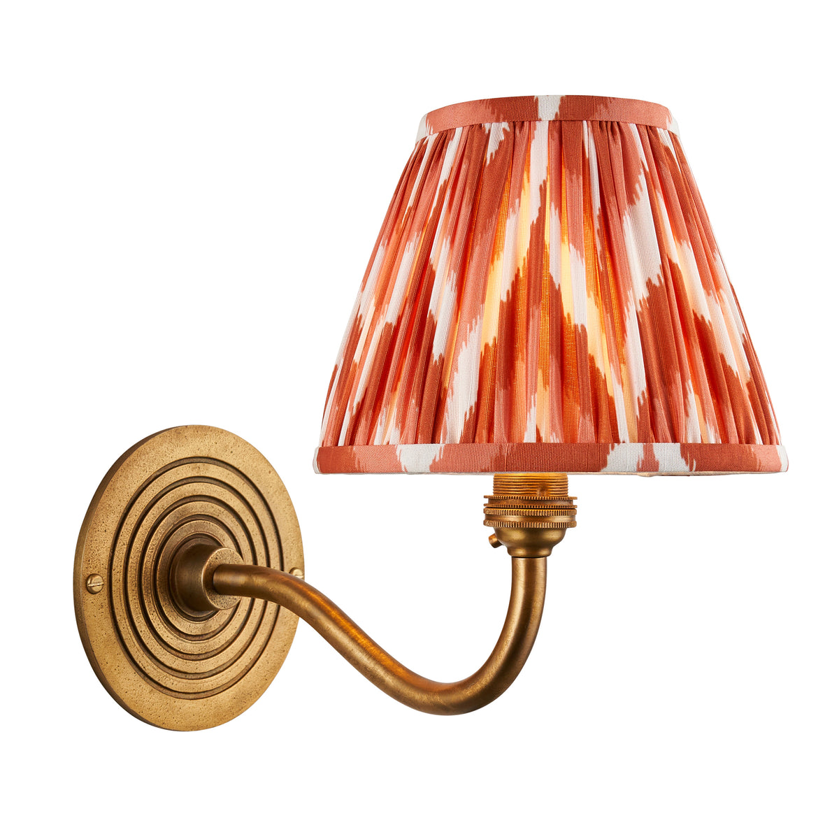 Endon Ripple Curve wall light unlit on a white background, antique brass concentric ring backplate and curved arm with apricot orange zigzag pleated shade