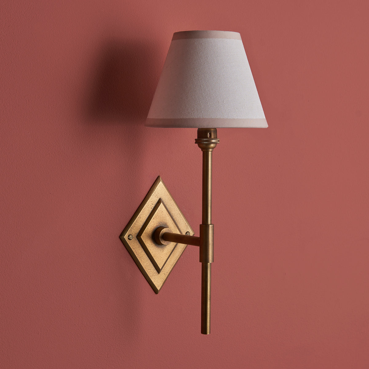 Endon Diamond Tall wall light unlit on a terracotta pink wall, showing the antique brass diamond backplate and vintage white shade