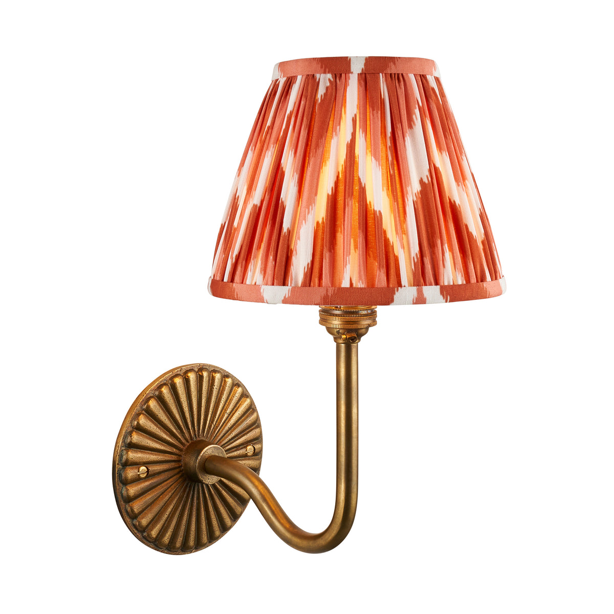 Endon Dahlia Swan wall light cut out on white, lit, antique brass sunburst backplate and swan neck arm with apricot orange zigzag pleated shade