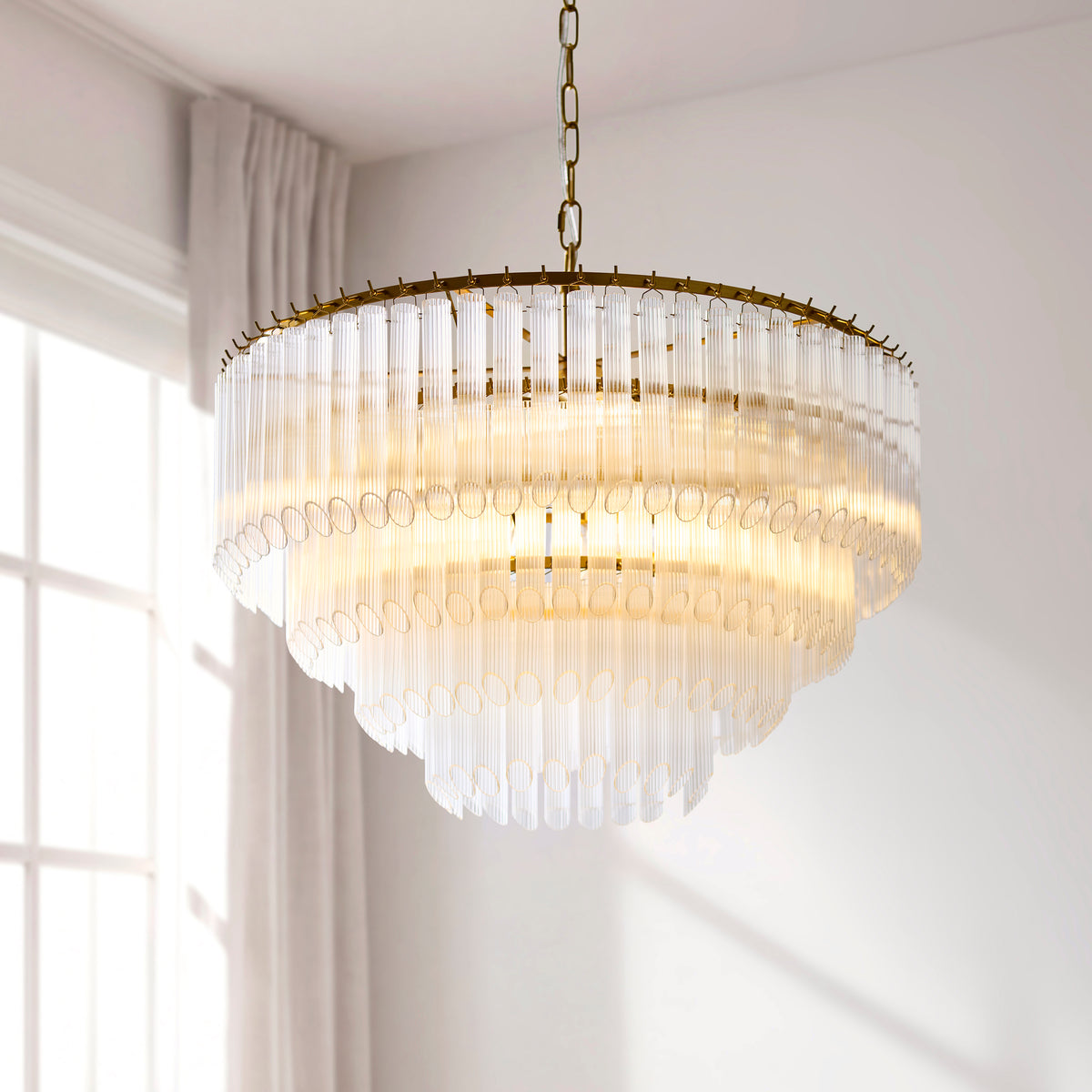 Close up of the brushed aged brass ceiling mount and top tier of the Endon Montpellier 6 light pendant with clear ribbed glass rods