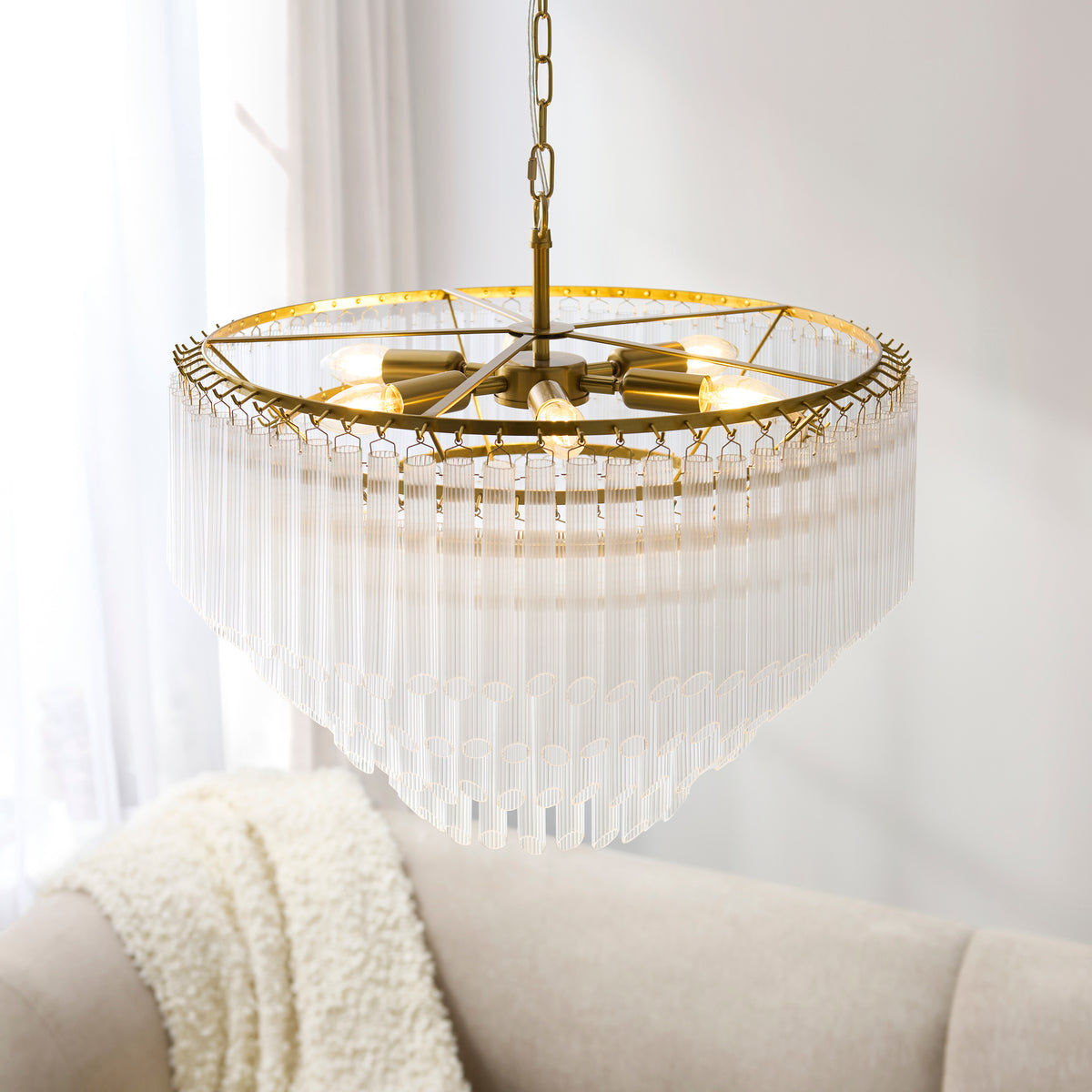 Detail shot of the clear ribbed glass rods hanging from the brushed aged brass frame of the Endon Montpellier 6 light pendant