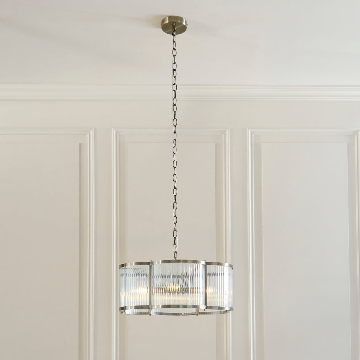 Endon Ridgeton Scallop five light pendant hanging on its chain in the panelled dining room, with a table set below.