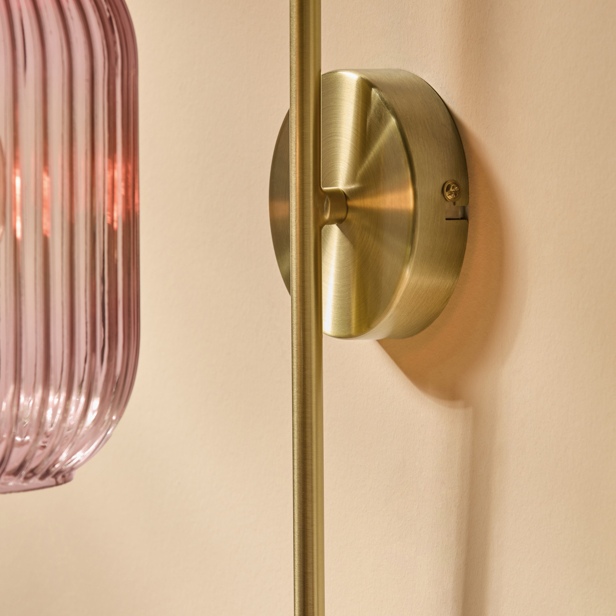 MADE Briz wall light close up of the brushed brass round backplate and curved arm