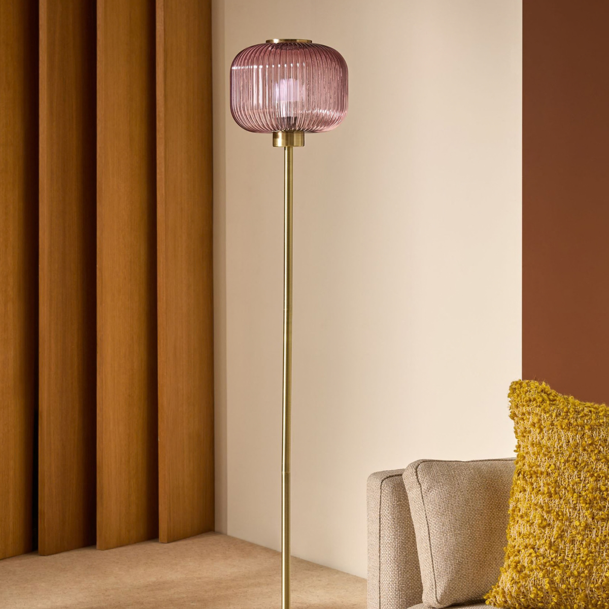 MADE.COM Briz floor lamp in brushed brass with ribbed pink glass shade, lifestyle shot against wood panelling