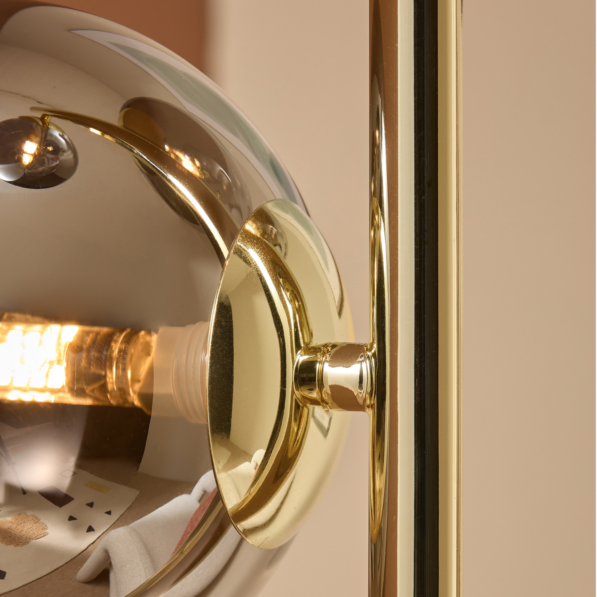 MADE.COM Globe floor lamp close up of a mirrored smoke grey glass globe and polished brass mount