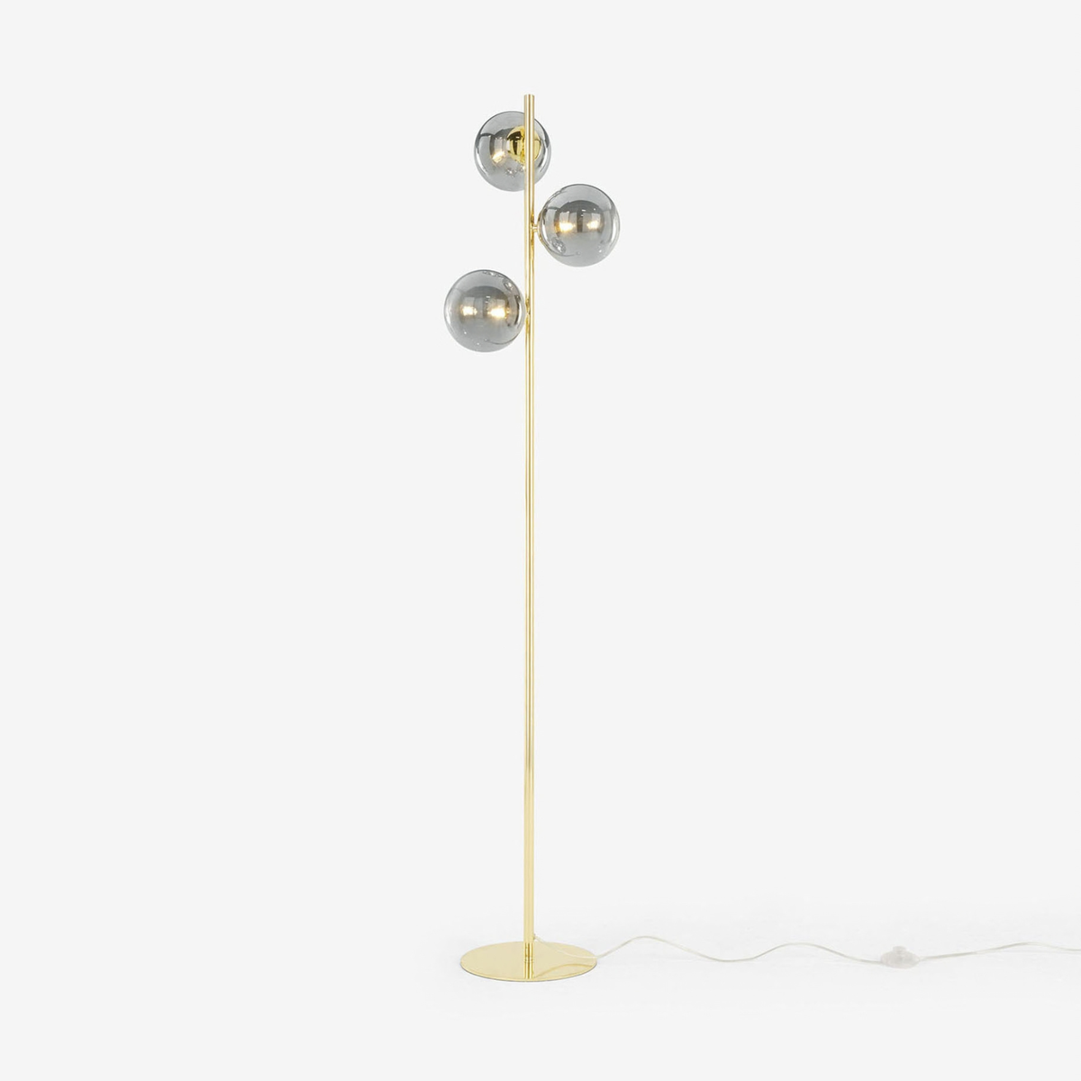 MADE Globe floor lamp in polished brass with three smoke grey glass globes, studio shot