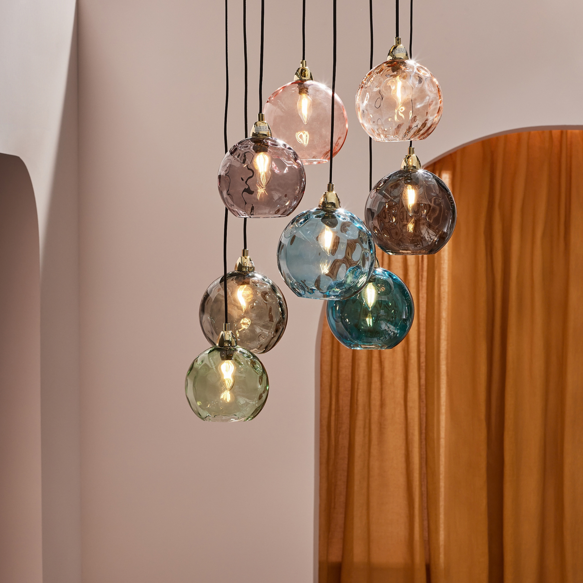 MADE Ilaria 8 light cluster pendant in polished brass with multicoloured dimpled glass shades, lifestyle shot
