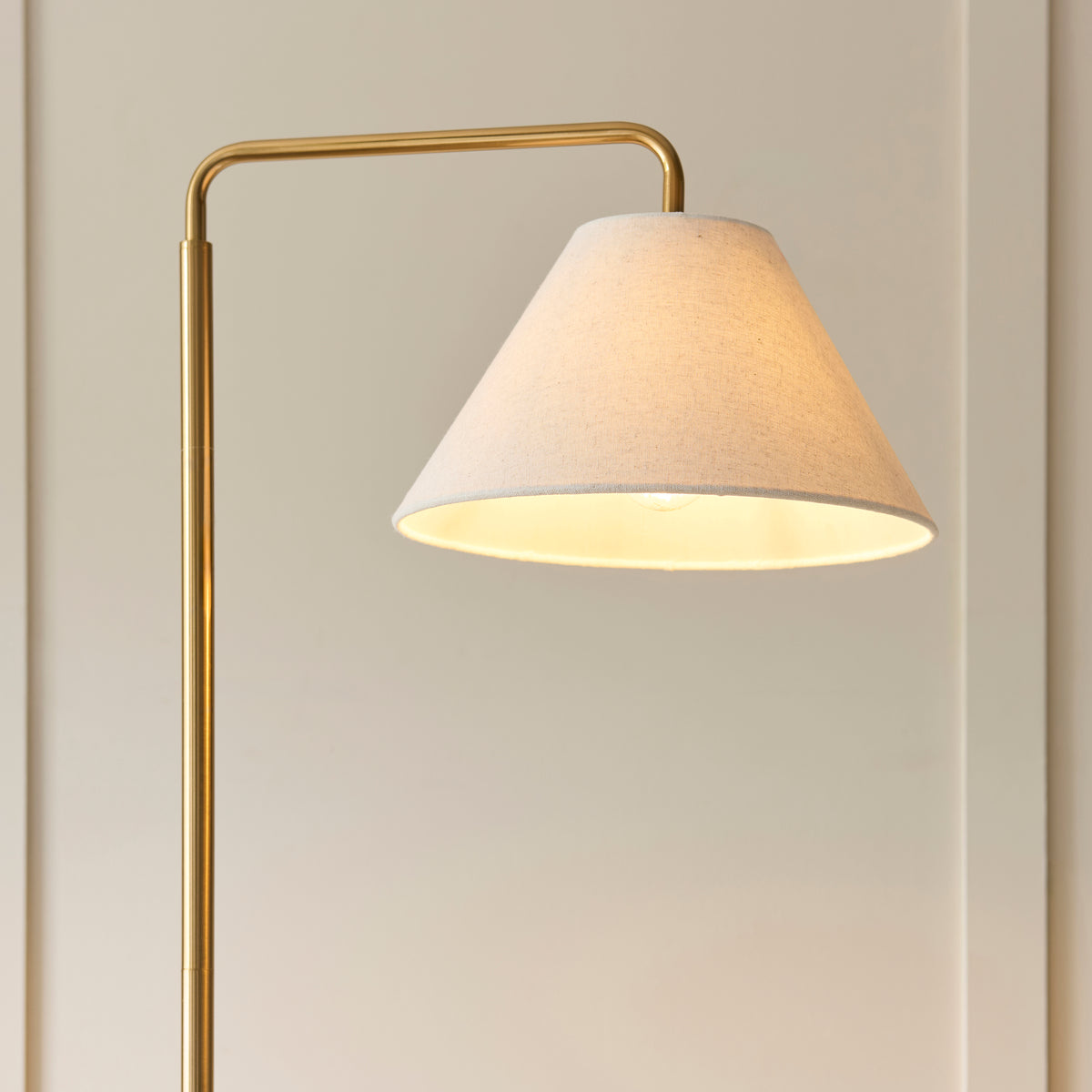 Endon Wallbridge floor light lit in a lifestyle living room scene beside a sofa on a neutral rug