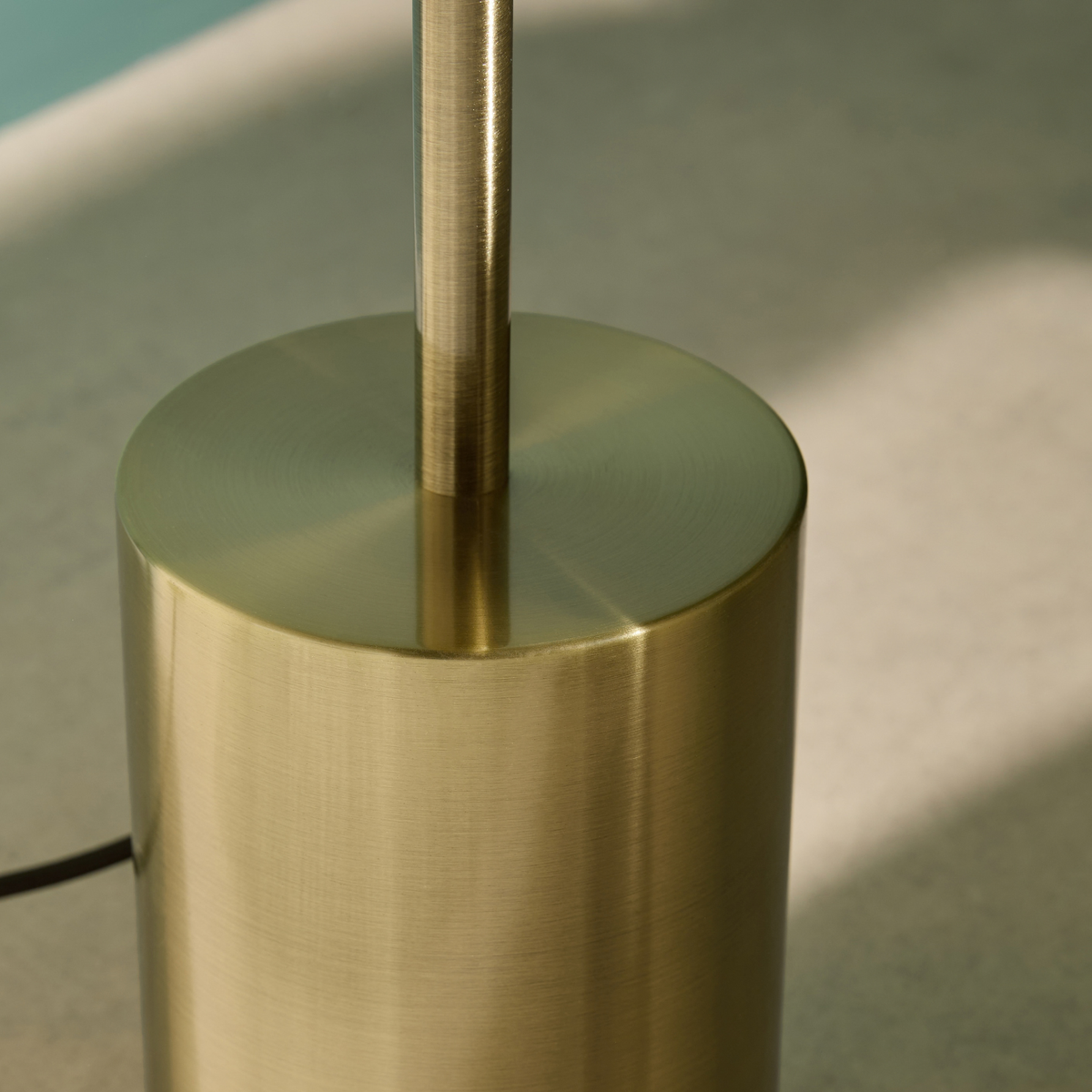MADE Briz floor lamp close up of the brushed brass cylinder base and stem