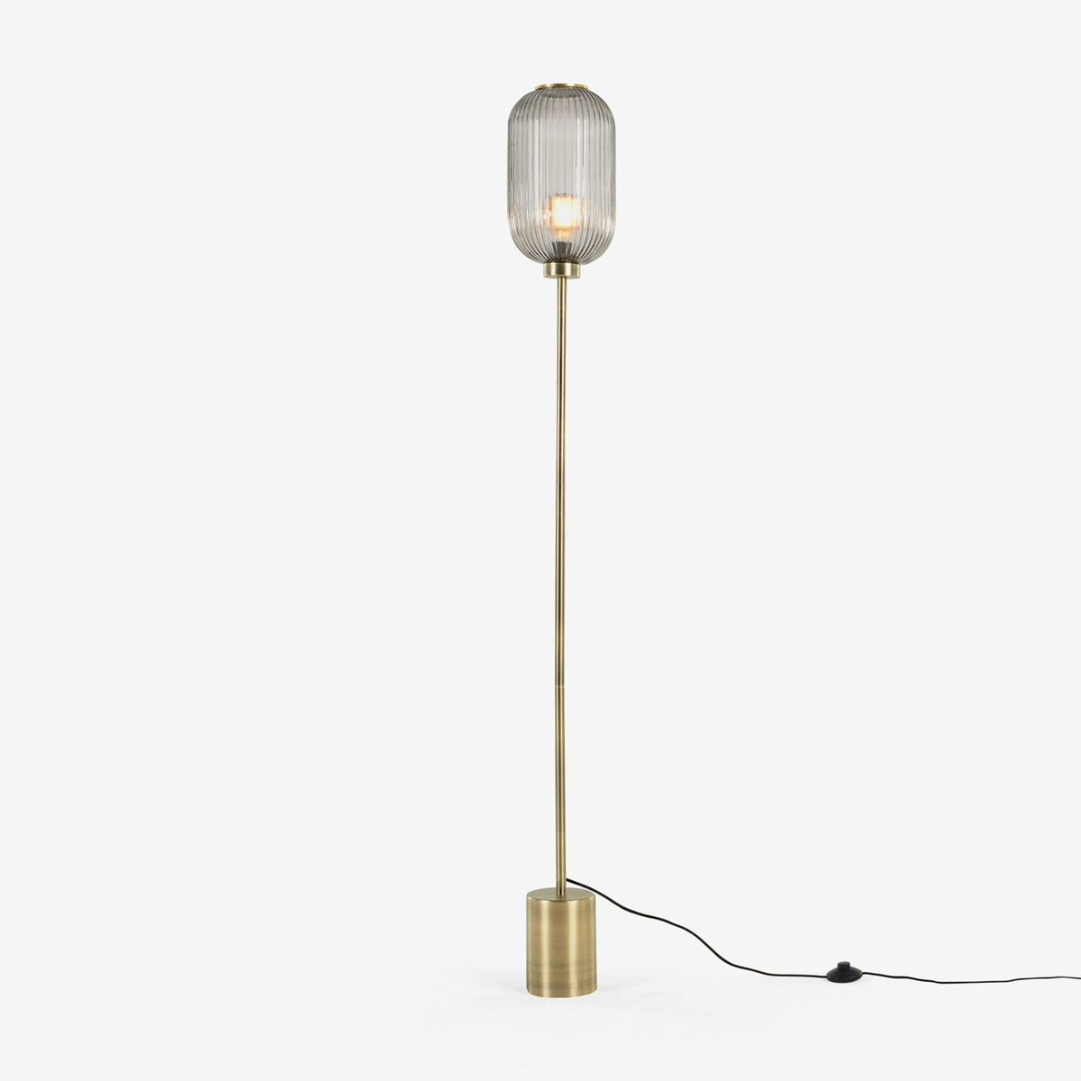 MADE Briz floor lamp in brushed brass with ribbed grey glass shade, full length studio shot with cable