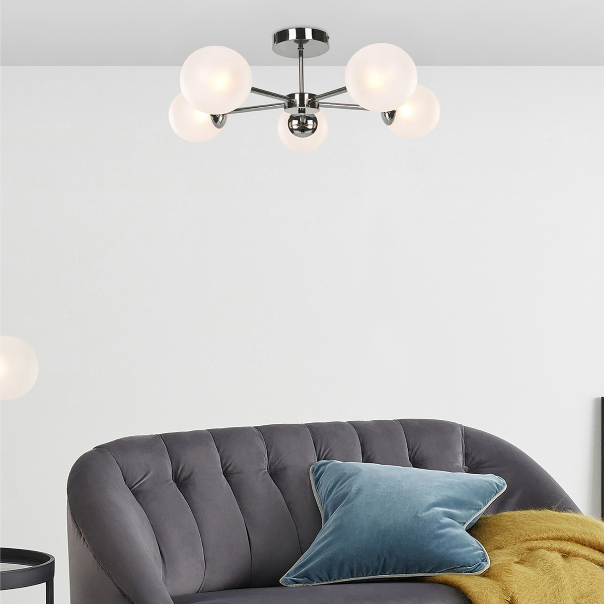 MADE.COM Globe 5 light flush ceiling light in chrome with frosted glass globes, lifestyle shot above a grey sofa