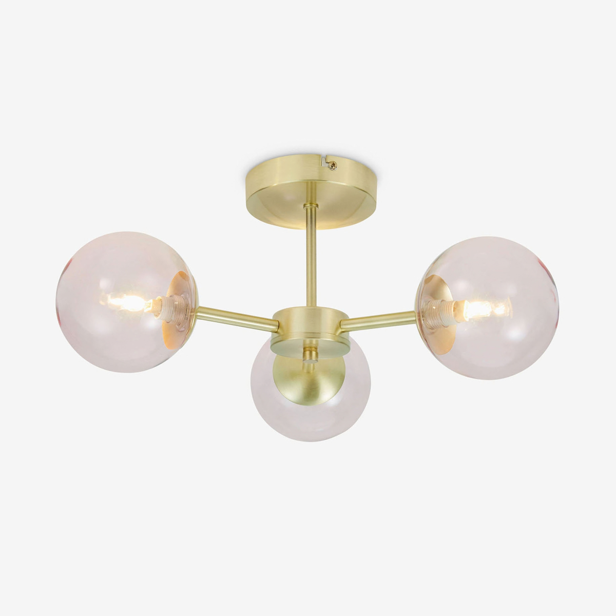MADE Globe 3 light flush ceiling light in brushed brass with pink tinted glass shades, studio shot