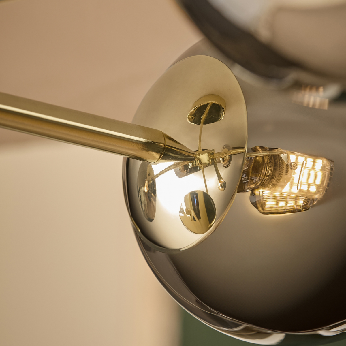 Close up of smoked mirrored glass globe with bulb and brass fitting on MADE.COM Globe ceiling light