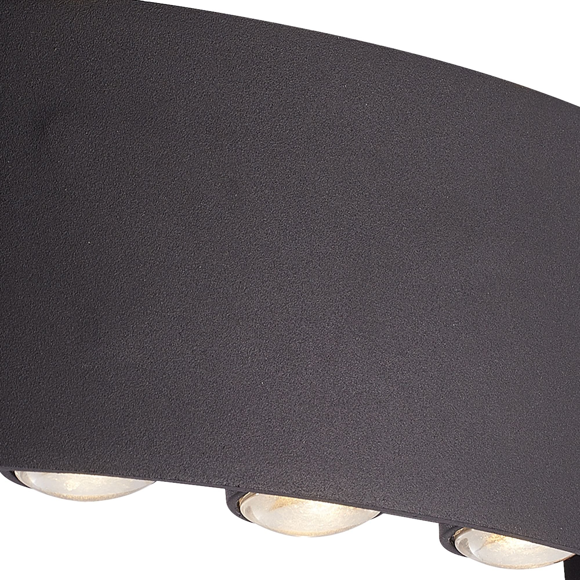 Close up of the Shadows LED outdoor wall light 18cm illuminated, showing warm white light spilling both up and down the wall from the three LED lens apertures