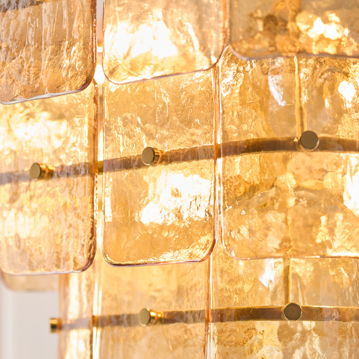 Endon Venice 10 light pendant in brushed aged brass with three tiers of champagne handmade textured glass shown lit as a plain product shot