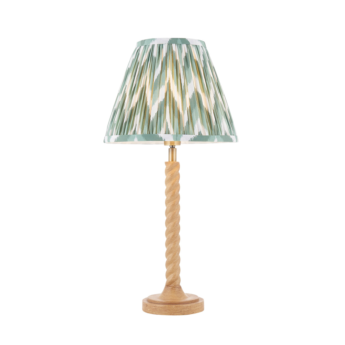 Endon Twist table lamp in oak effect resin with Cotswold green zigzag pleated shade, lit, shown on a white background
