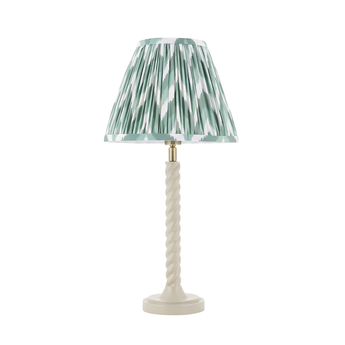 Endon Twist table lamp unlit, satin almond white twisted resin stem with a green and white zigzag pleated shade, cut out on white