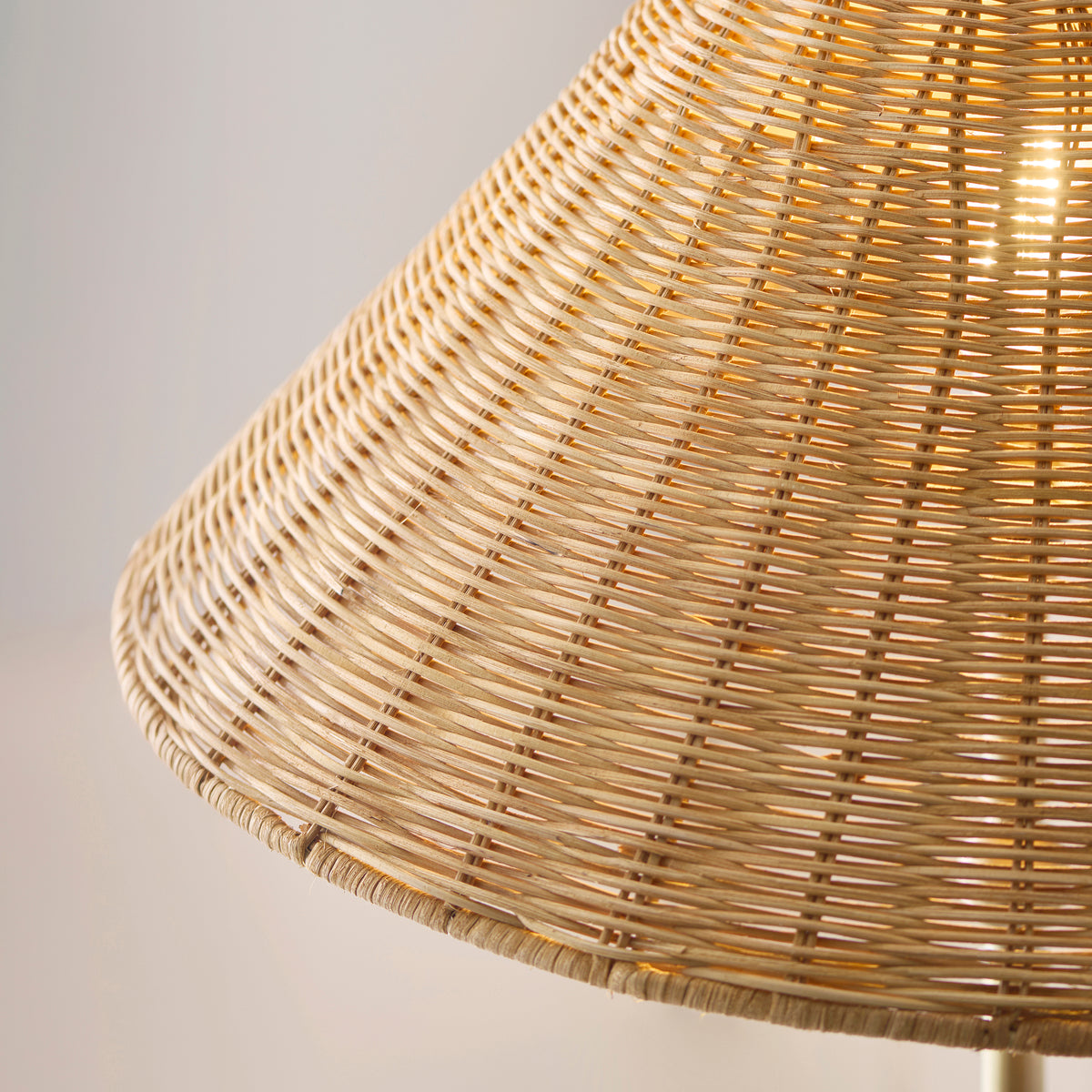 Close up detail of the rattan weave on the Endon Arlo floor lamp shade, glowing warmly with the bulb lit