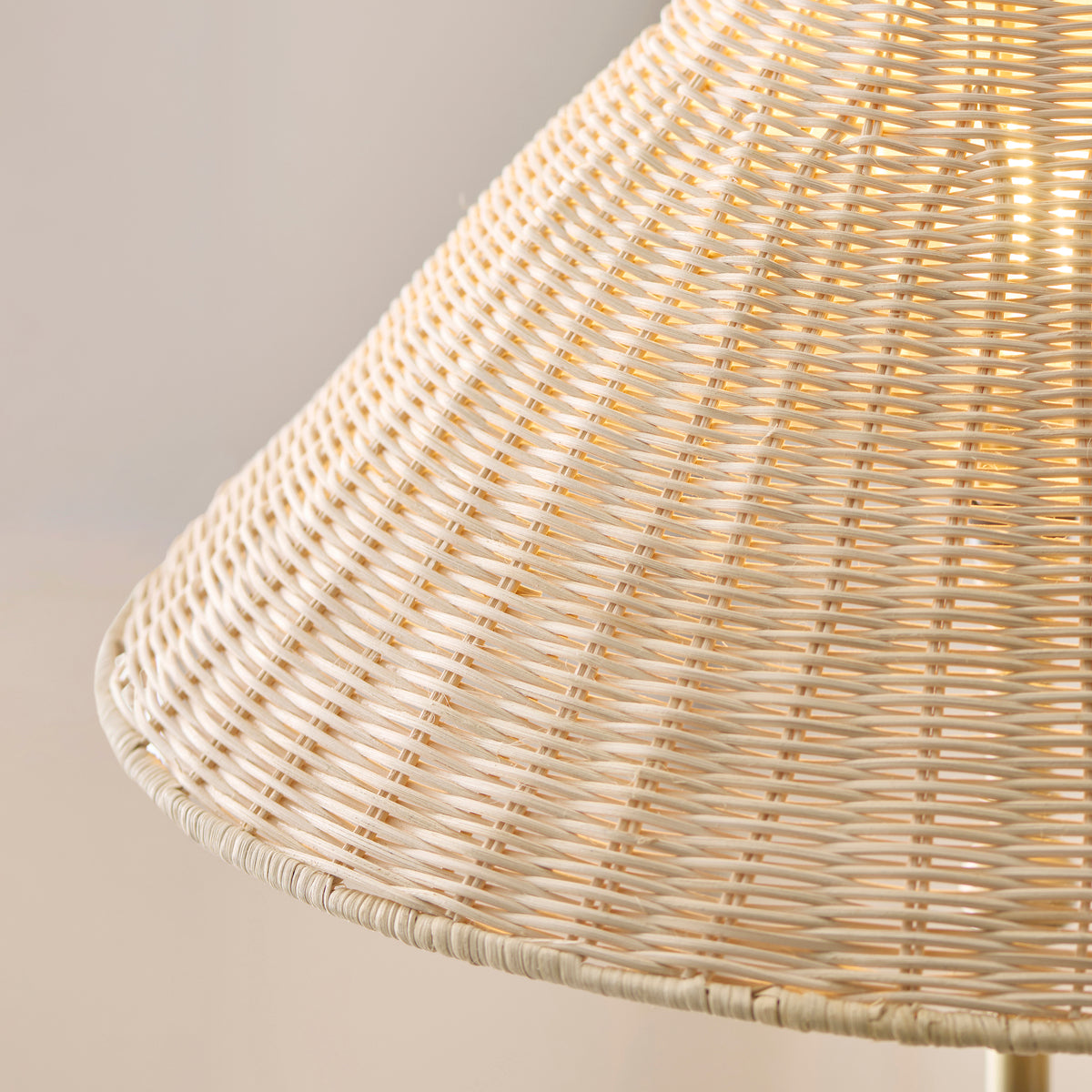 Detail of the woven rattan shade edge on the Endon Arlo floor lamp, lit so the pale weave glows warm